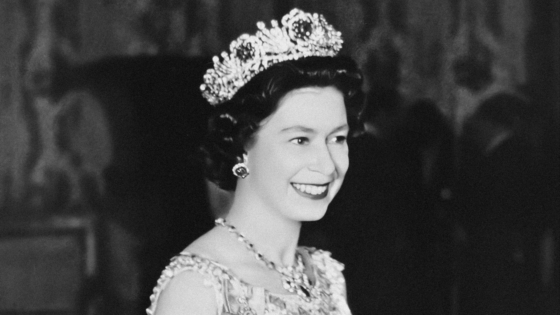 a black and white photo of a woman wearing a tiara