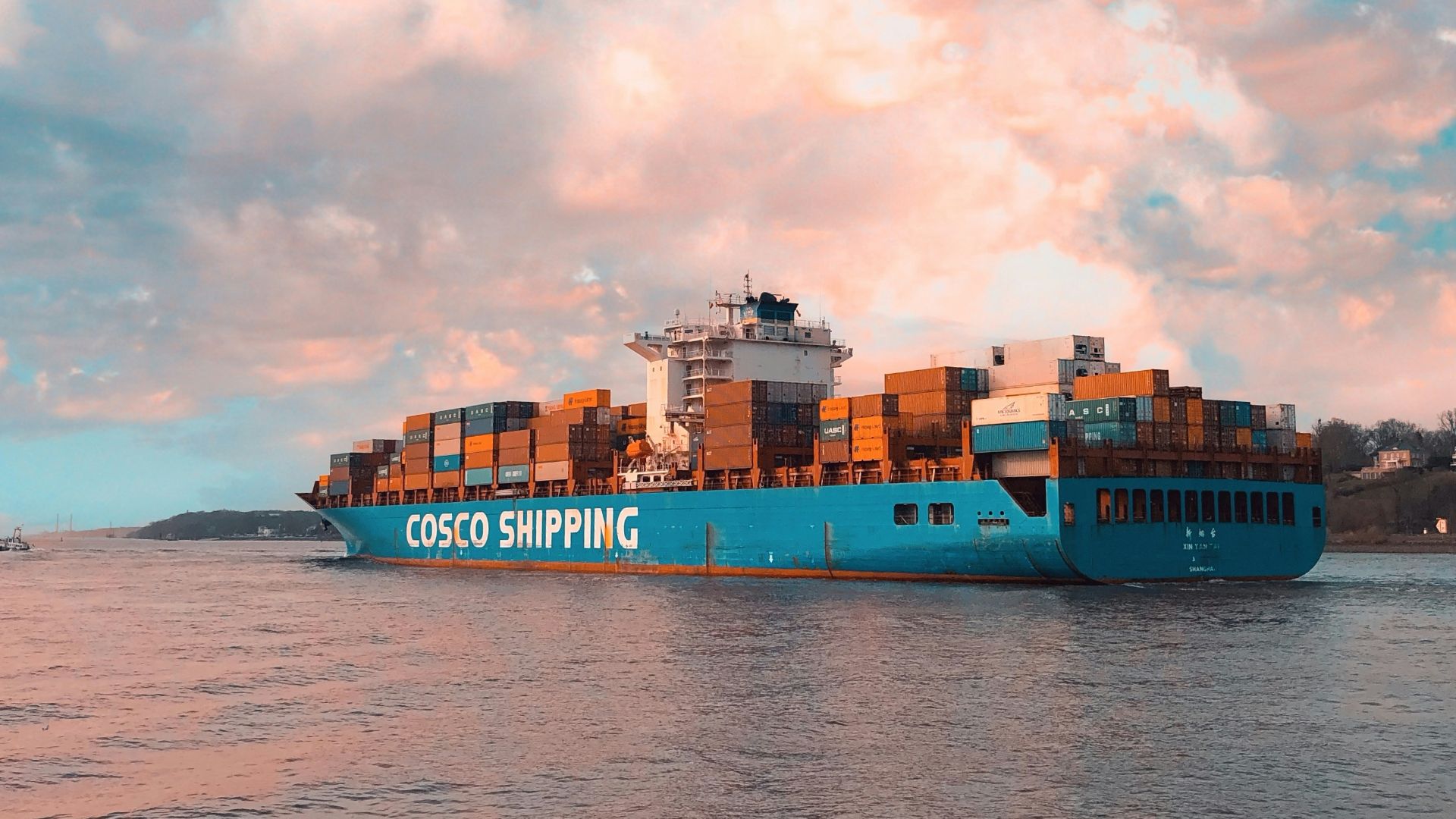 blue cargo ship on sea under cloudy sky during daytime