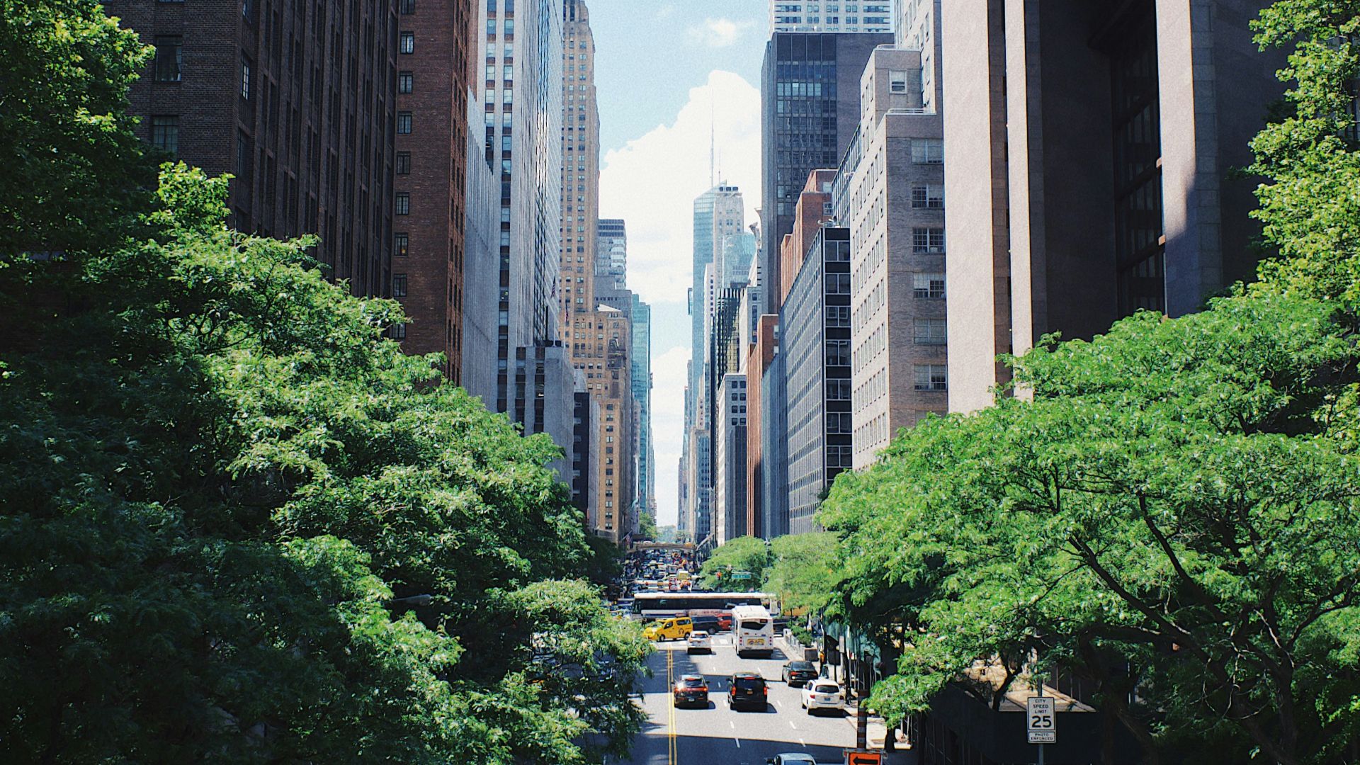 yellow car running on the street between the building during daytime
