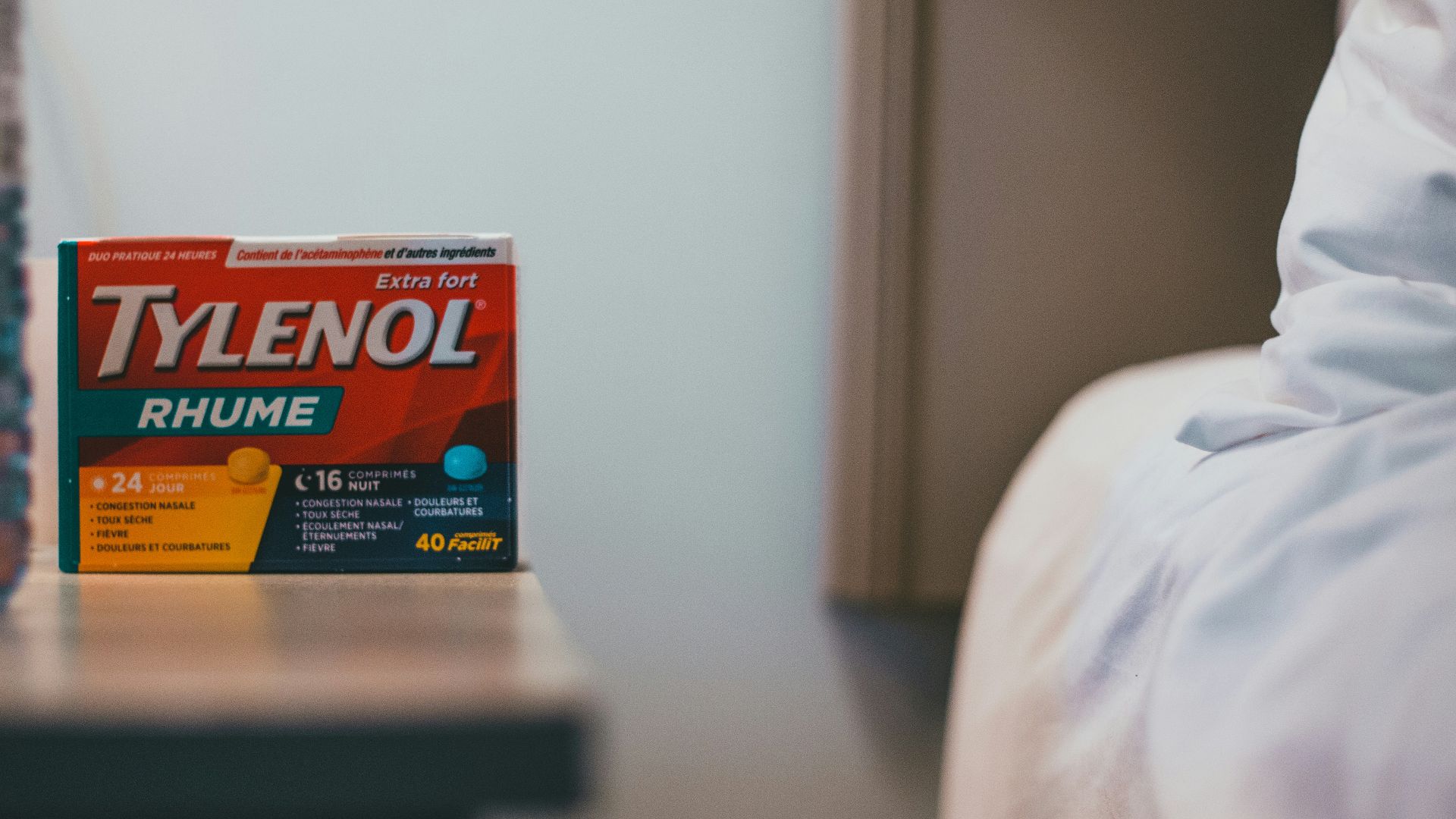 a bottle of tylenol next to a bed