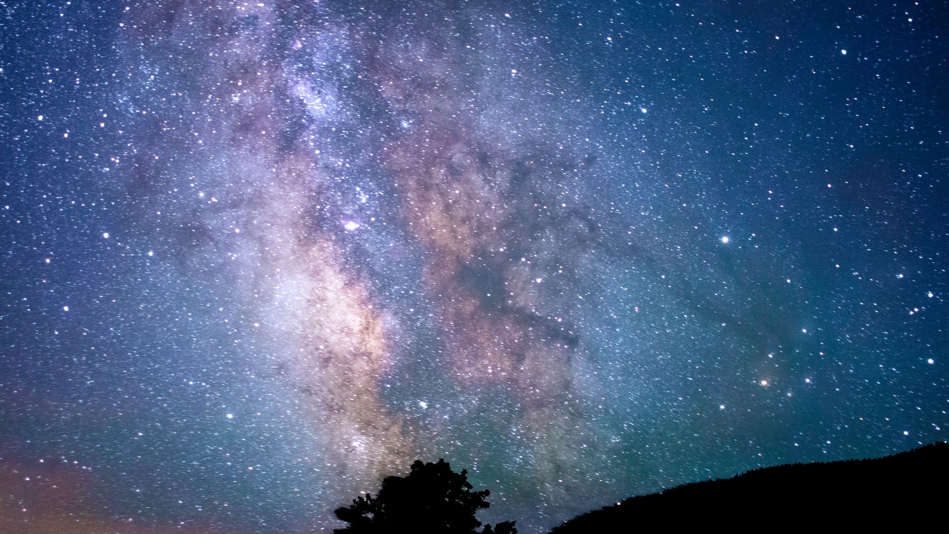 silhouette of trees and mountain under blue sky at nighttime