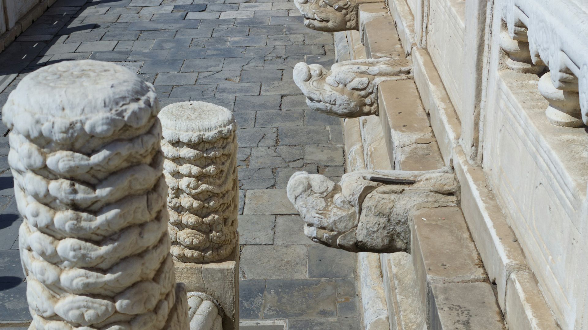 A man standing on top of a stone wall next to a building