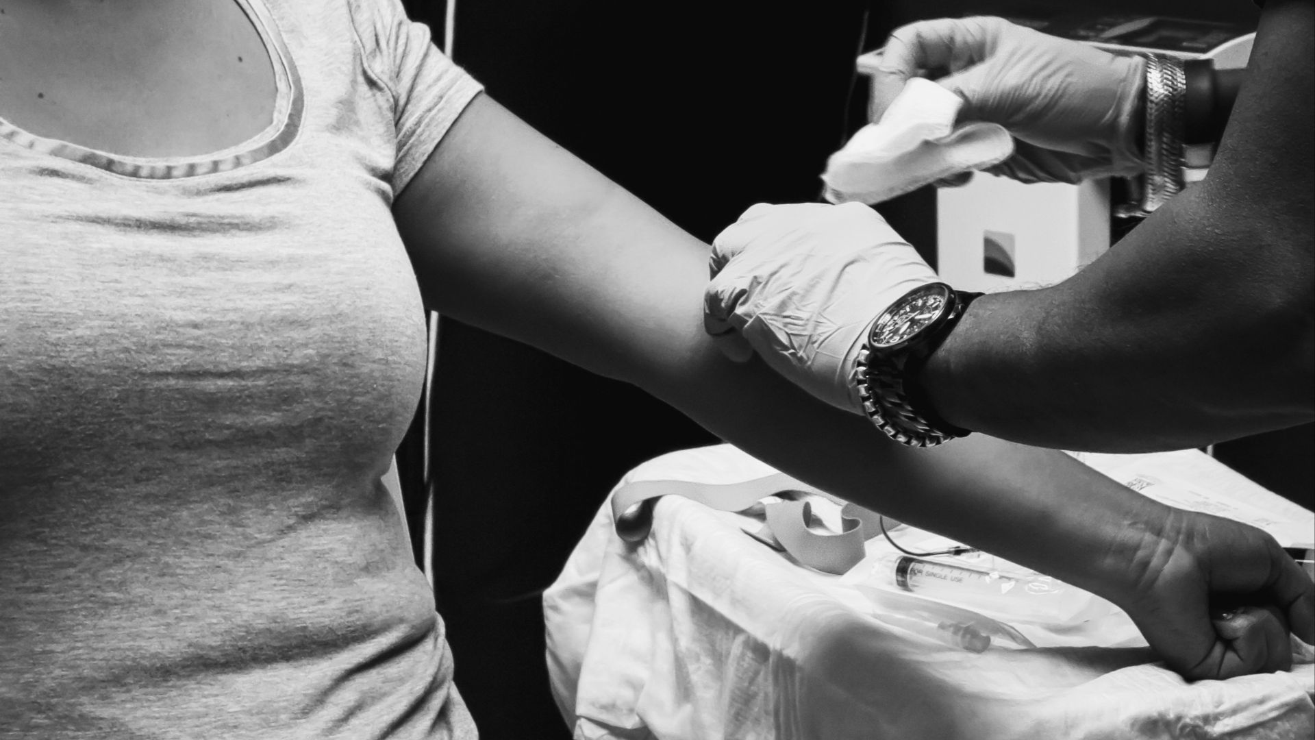 grayscale photo of man in t-shirt and watch holding smartphone