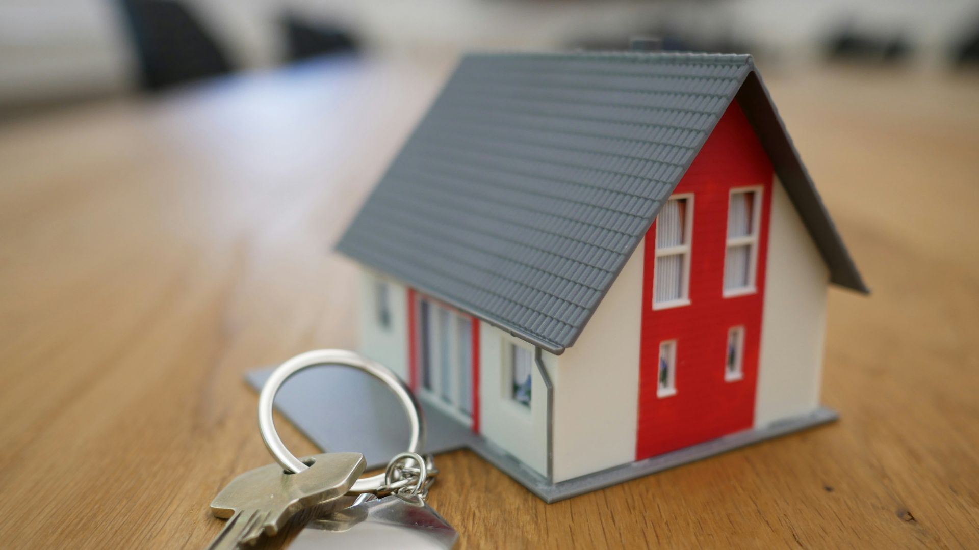 white and red wooden house miniature on brown table