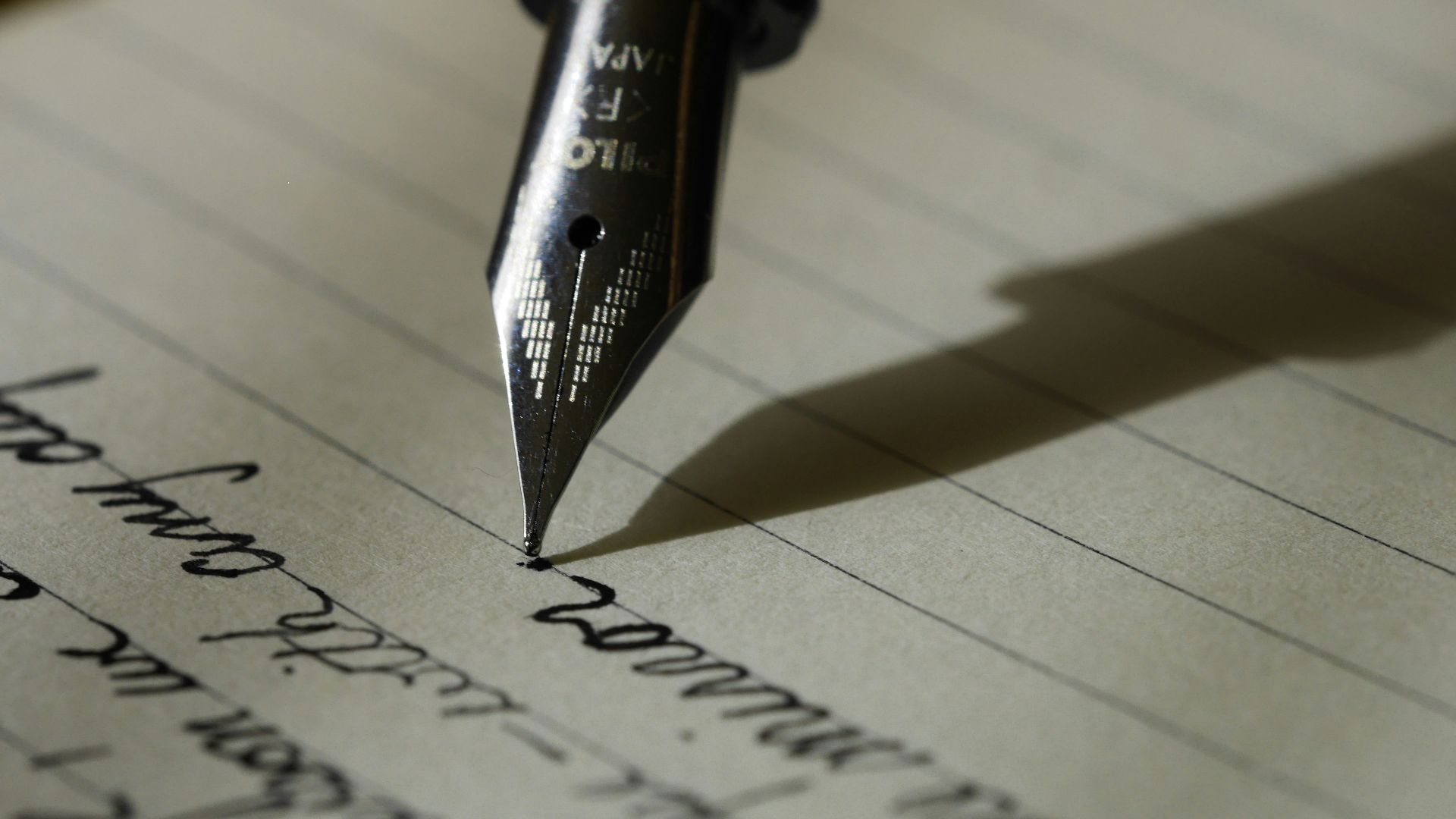 fountain pen on black lined paper