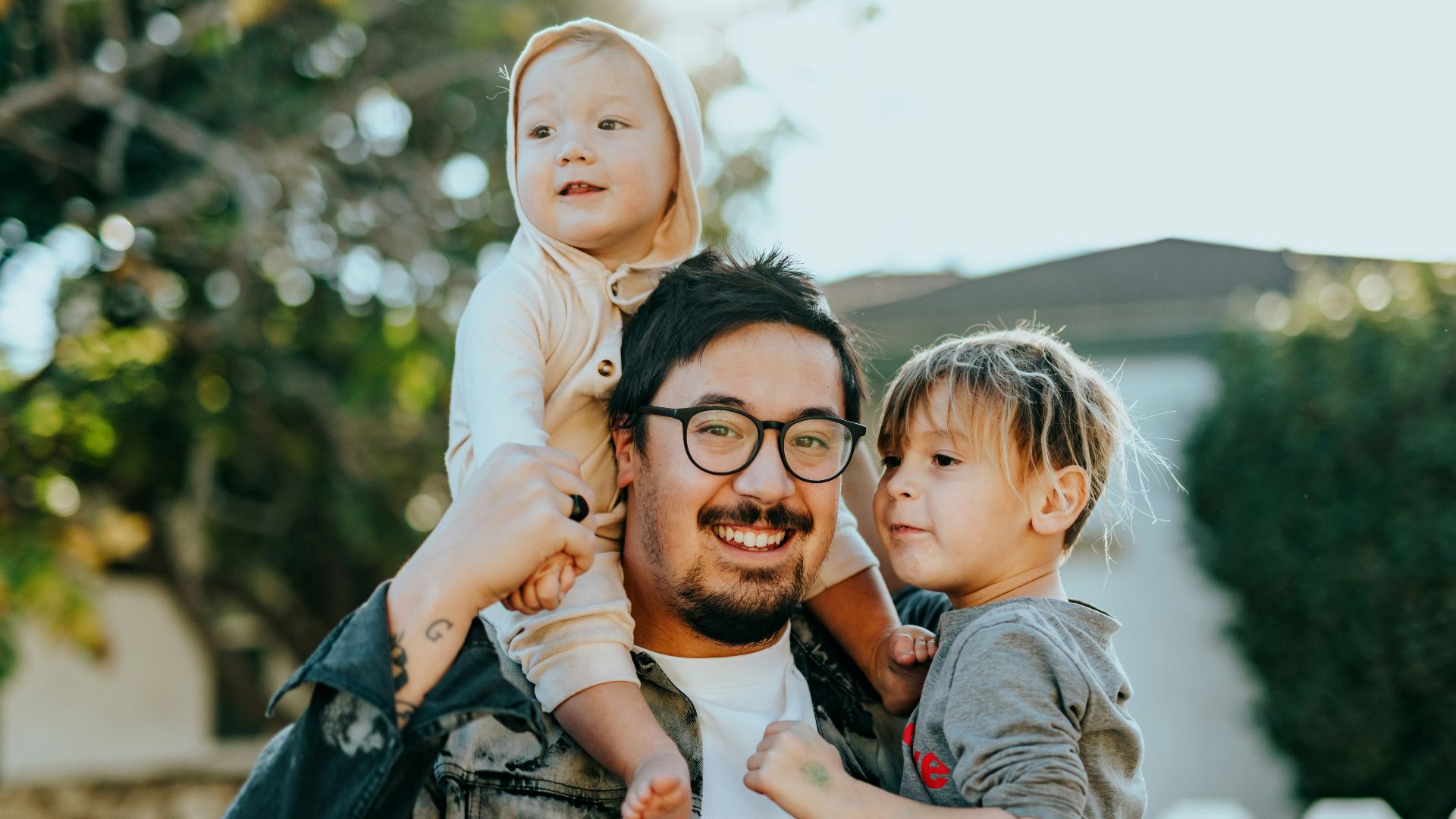 man in white shirt carrying girl in gray shirt