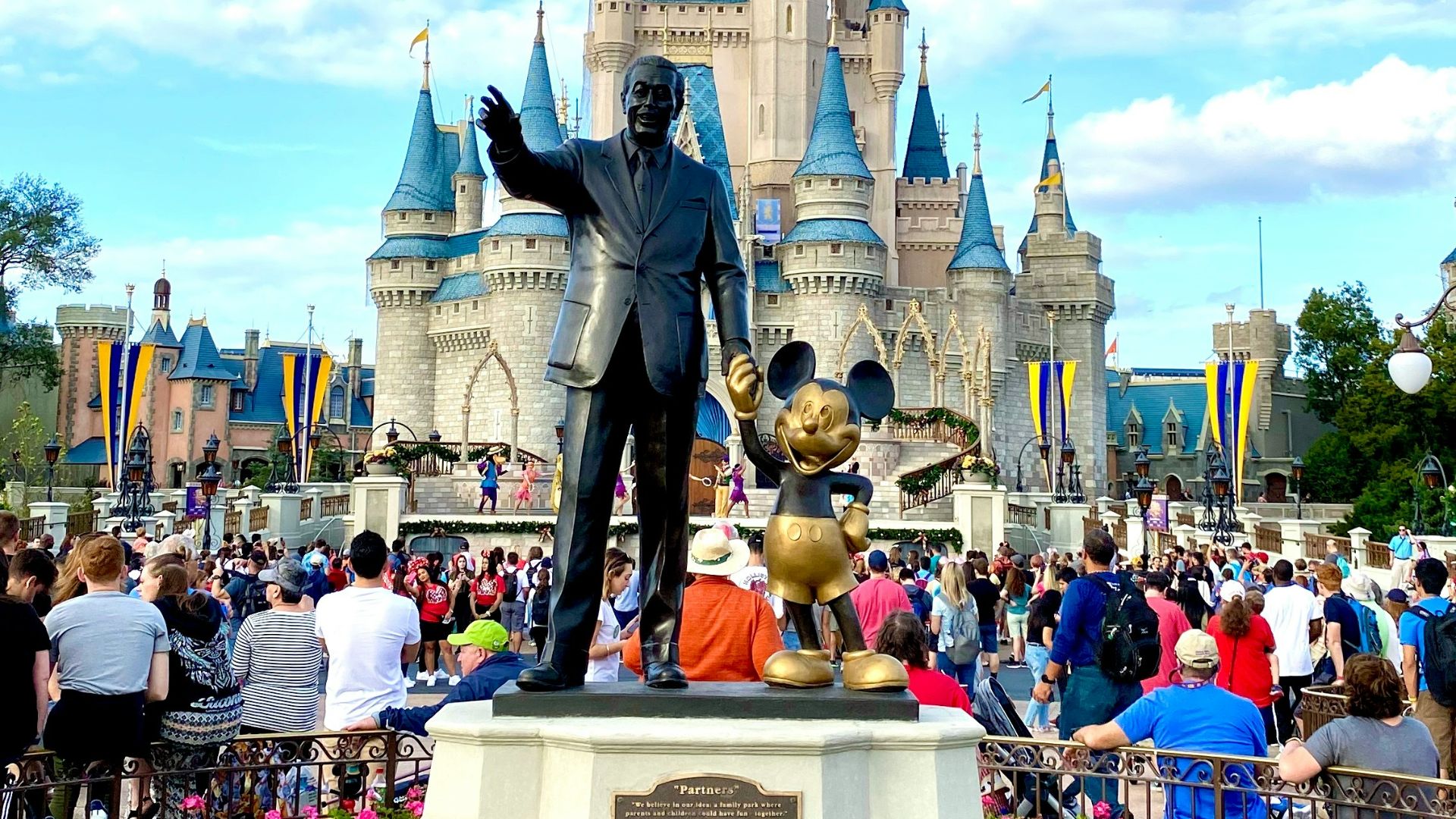 people walking on park near disney castle during daytime