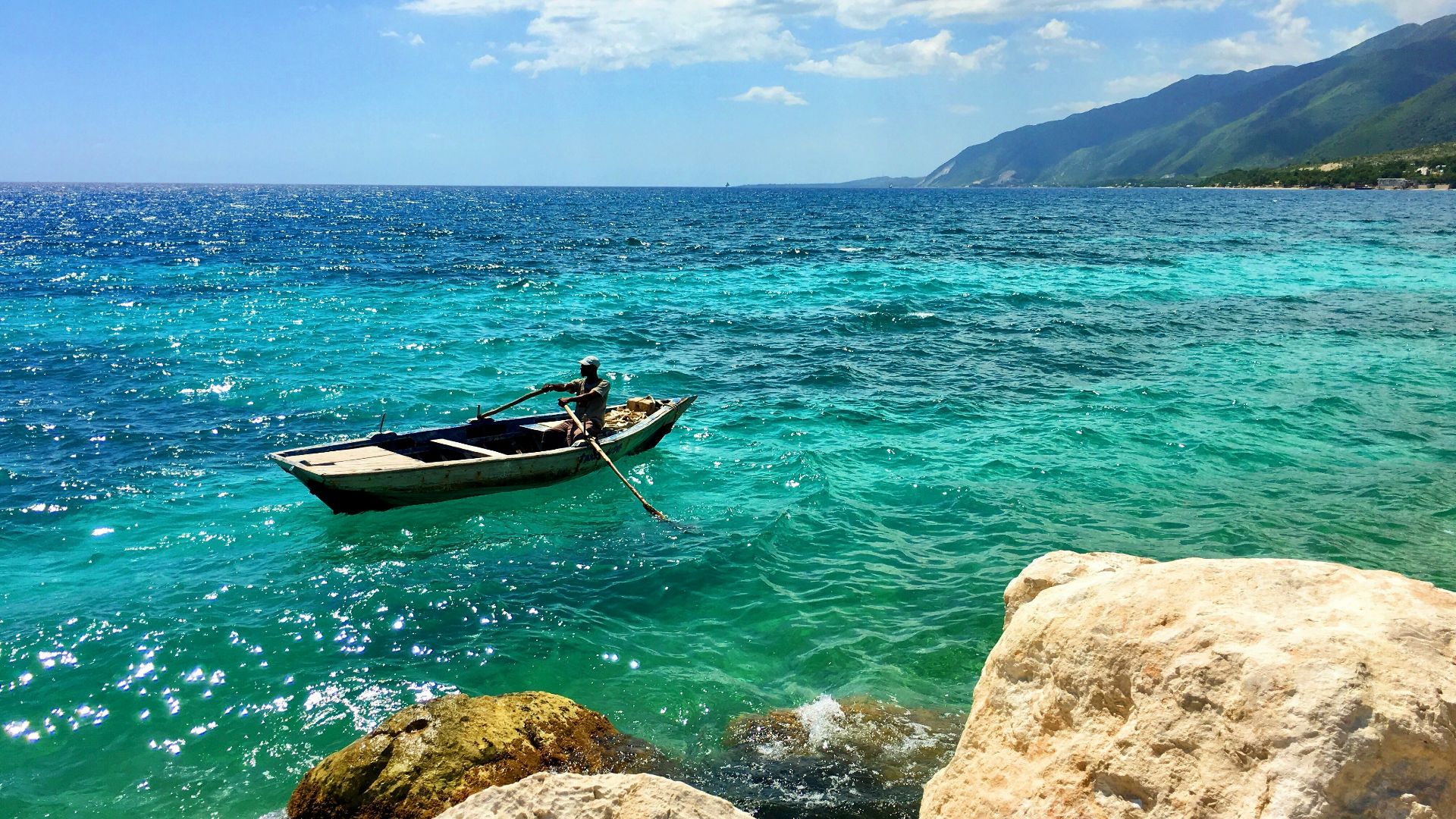 man in red shirt riding on boat on sea during daytime