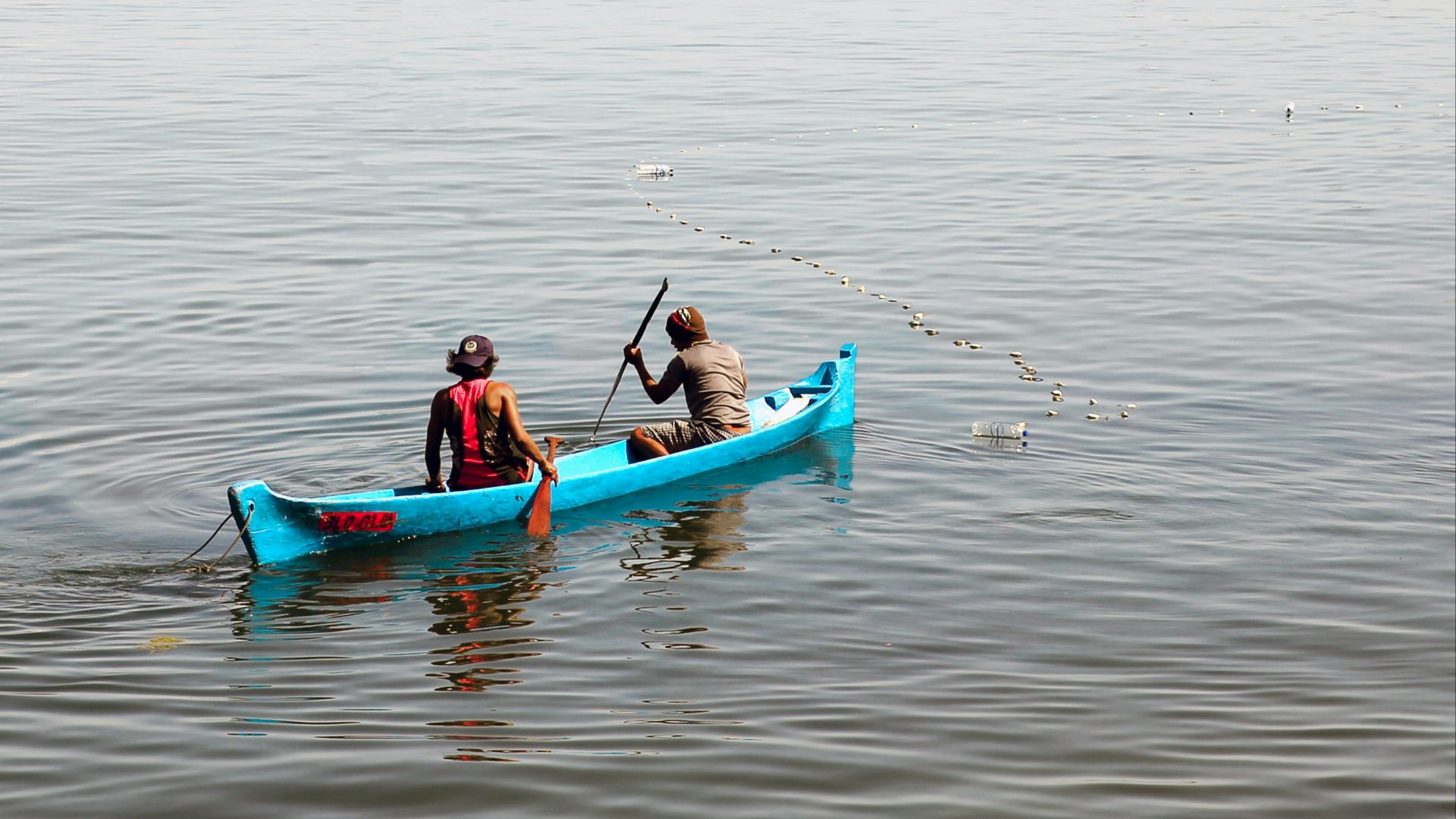 2 person in boat at body of water