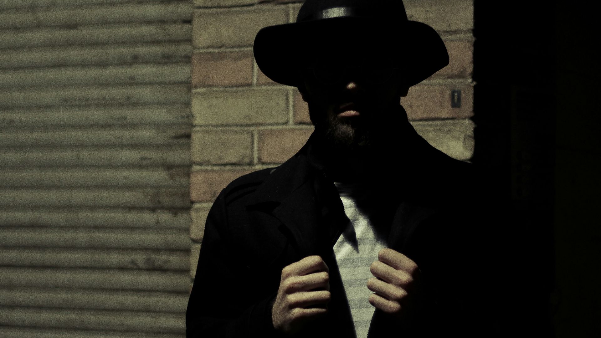 man wearing black fedora hat and black suit jacket