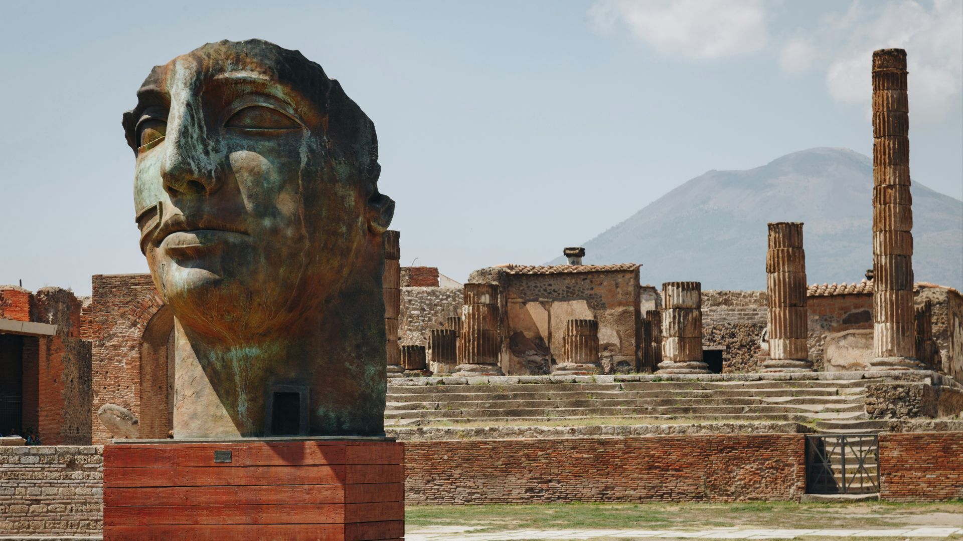 a statue of a woman's head in front of ruins