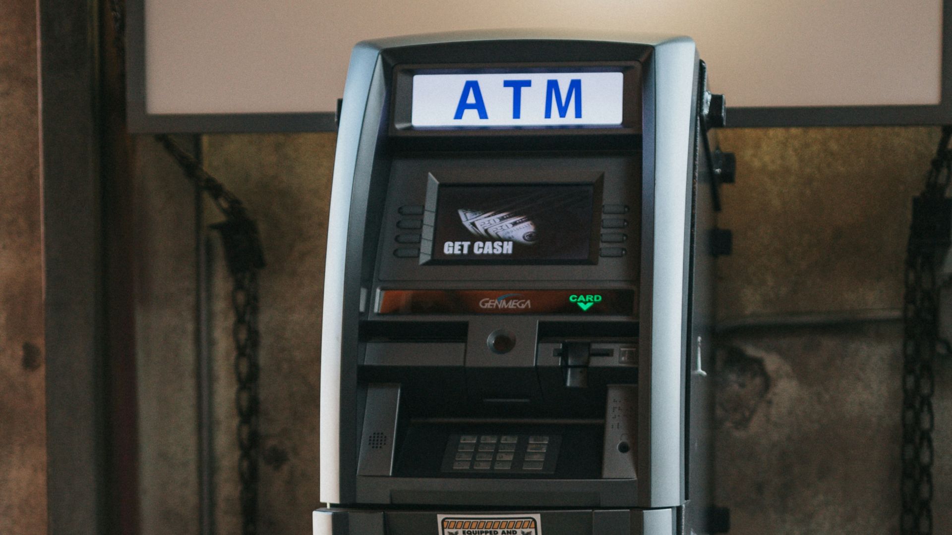 a atm machine sitting in front of a building