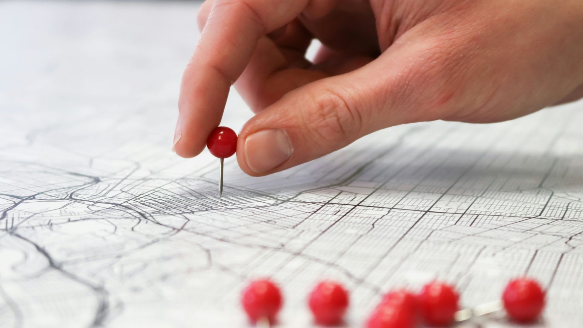 person holding red round medication pill