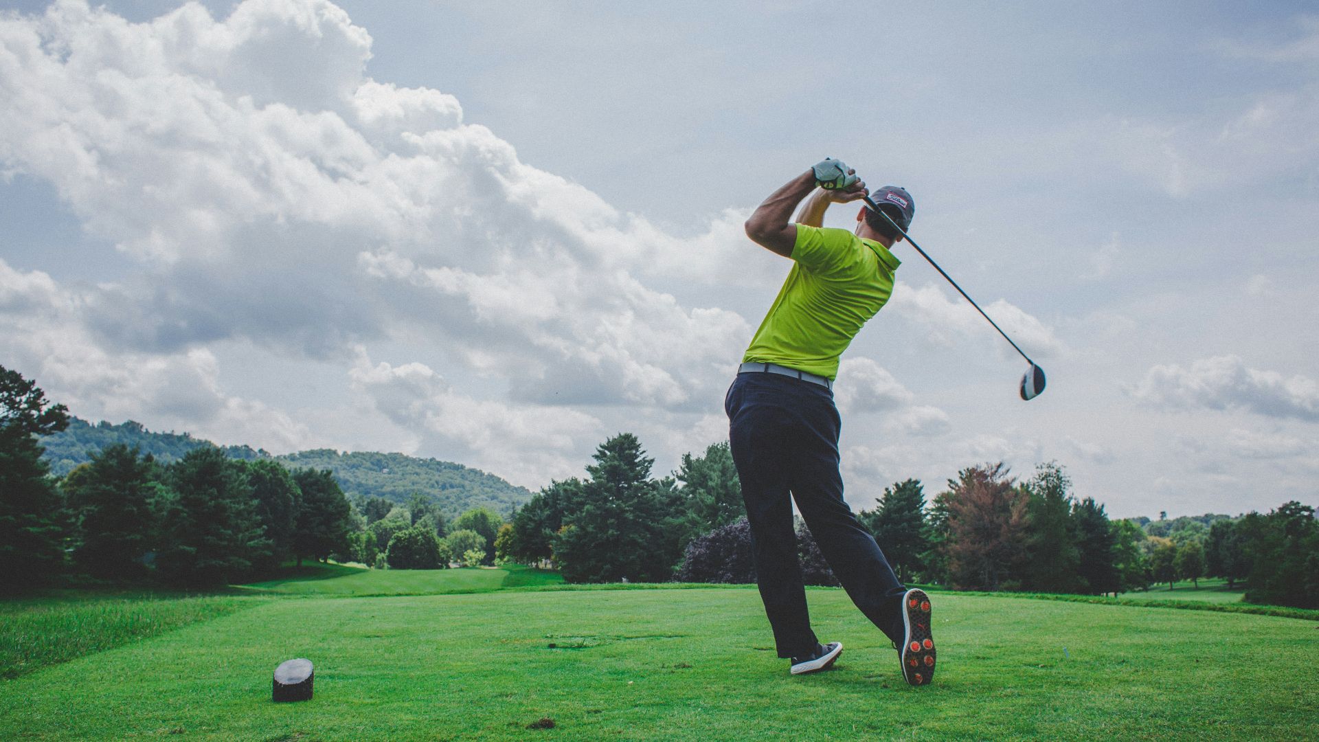 photo of man swinging golf driver