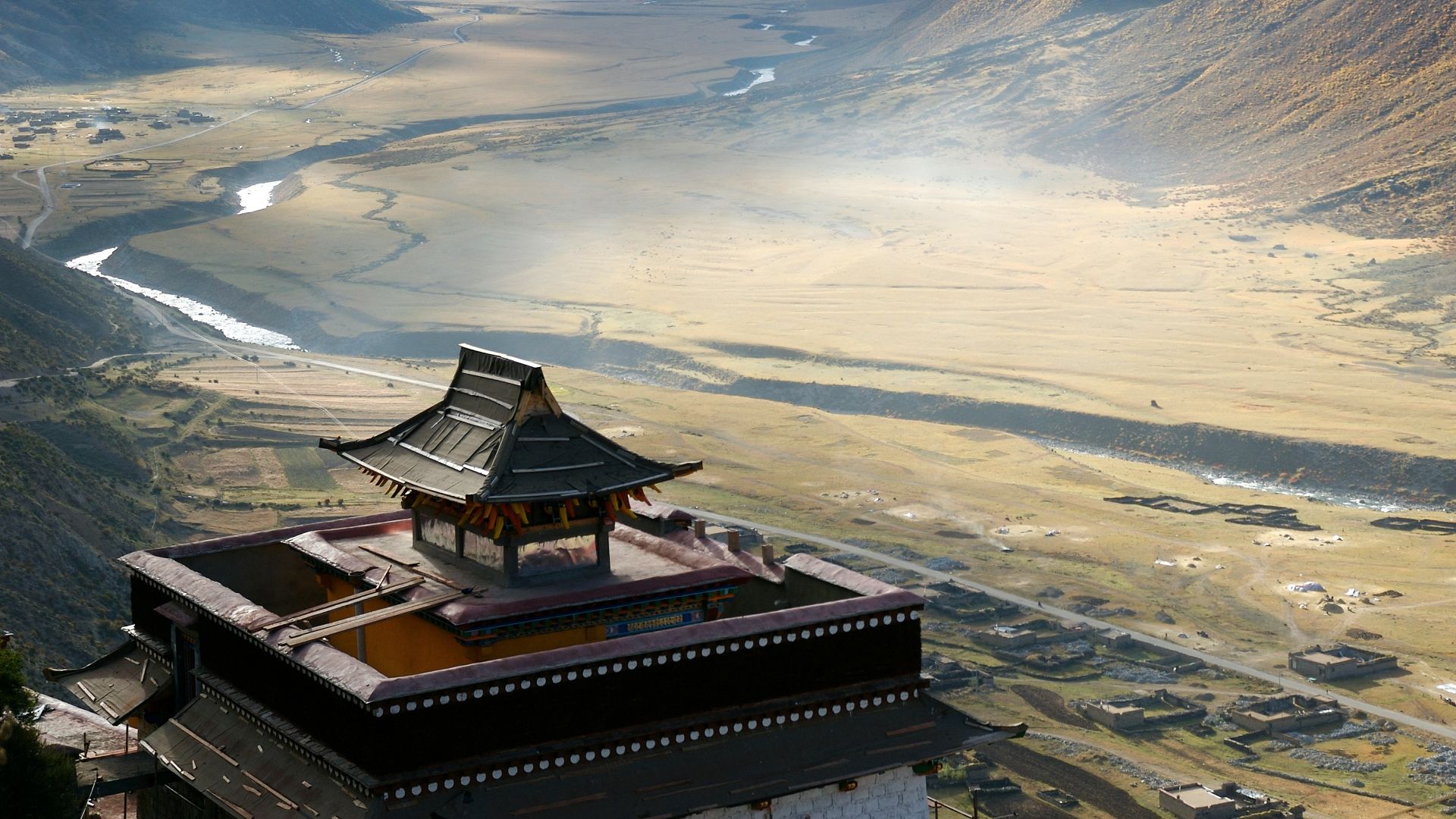 red and brown wooden house near green field viewing mountain under blue and gray skies