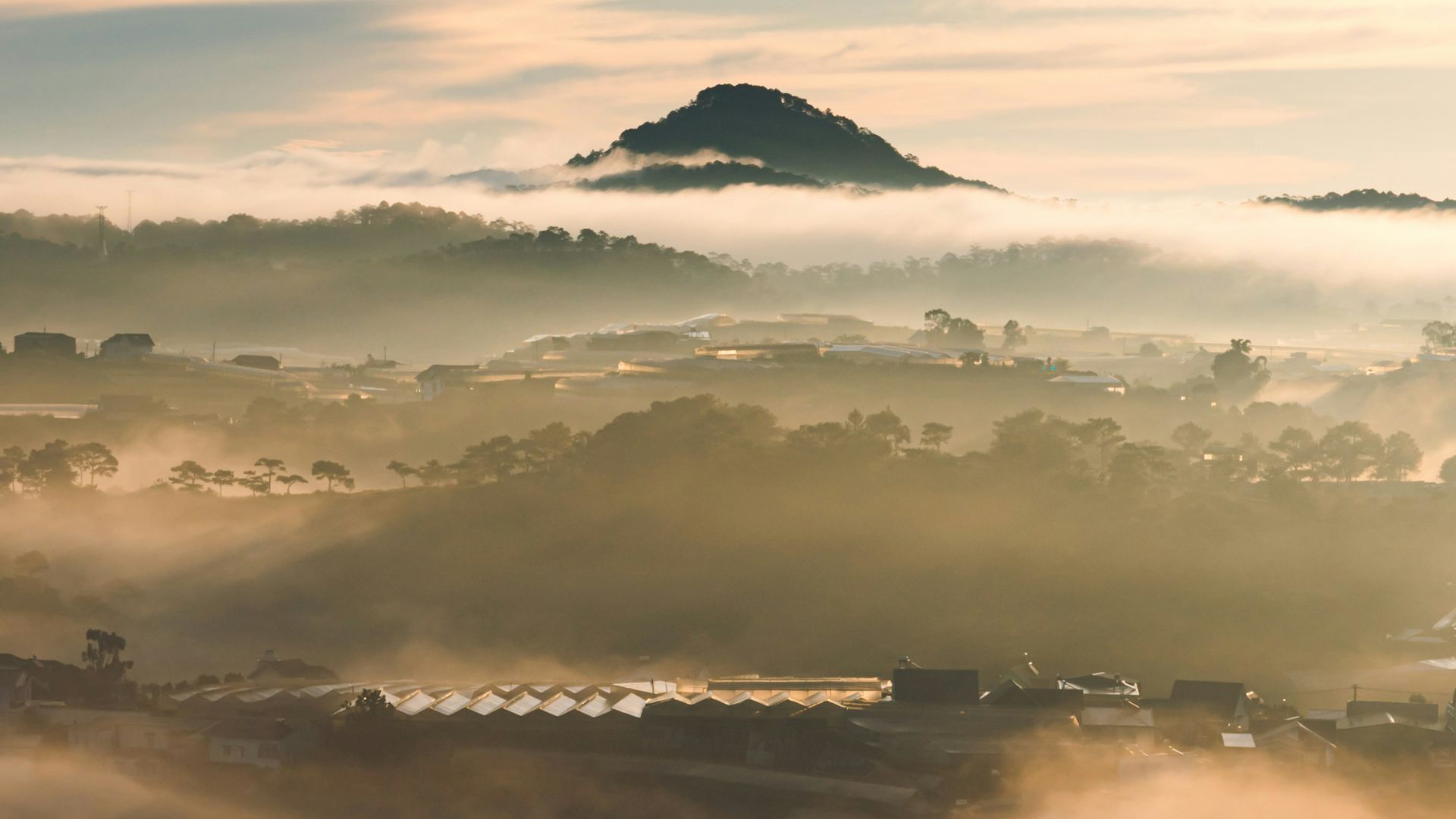 a foggy landscape with a small island in the distance