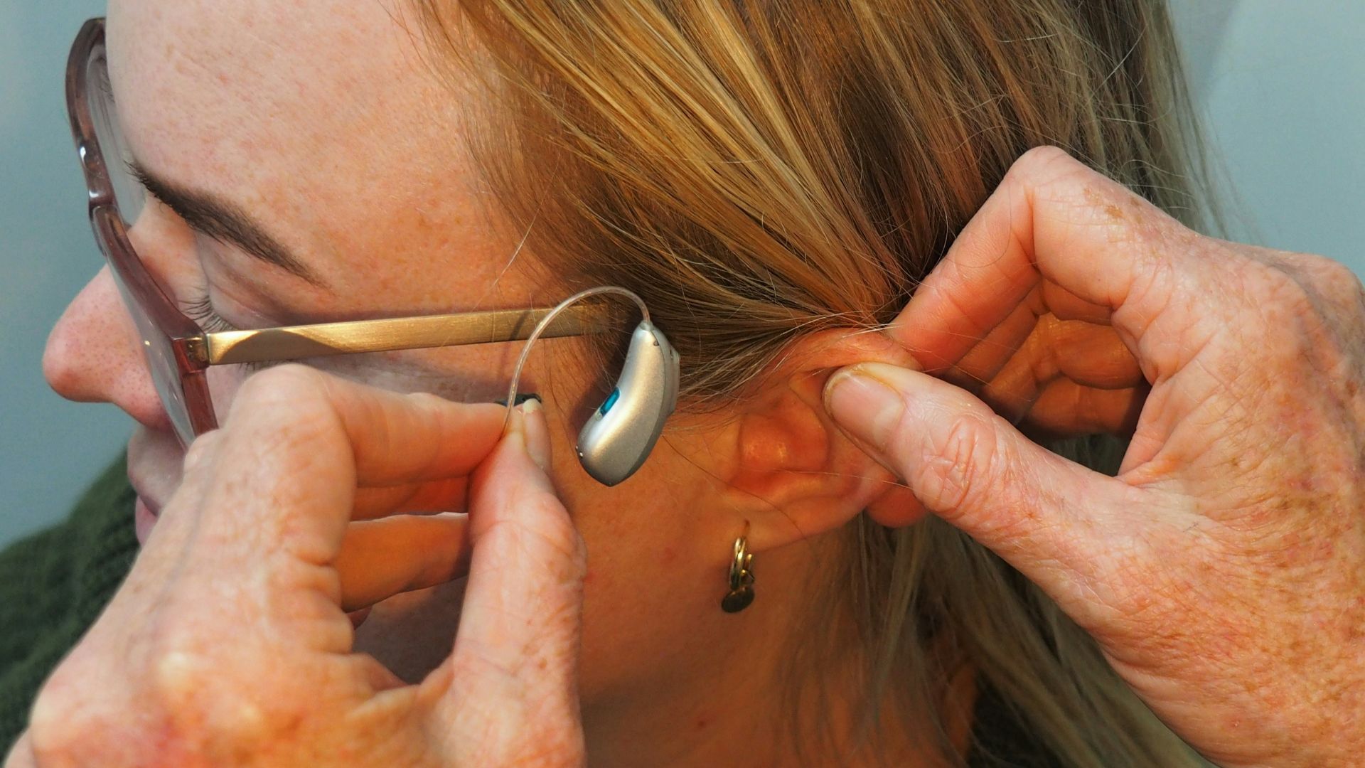 a woman is putting on a pair of glasses