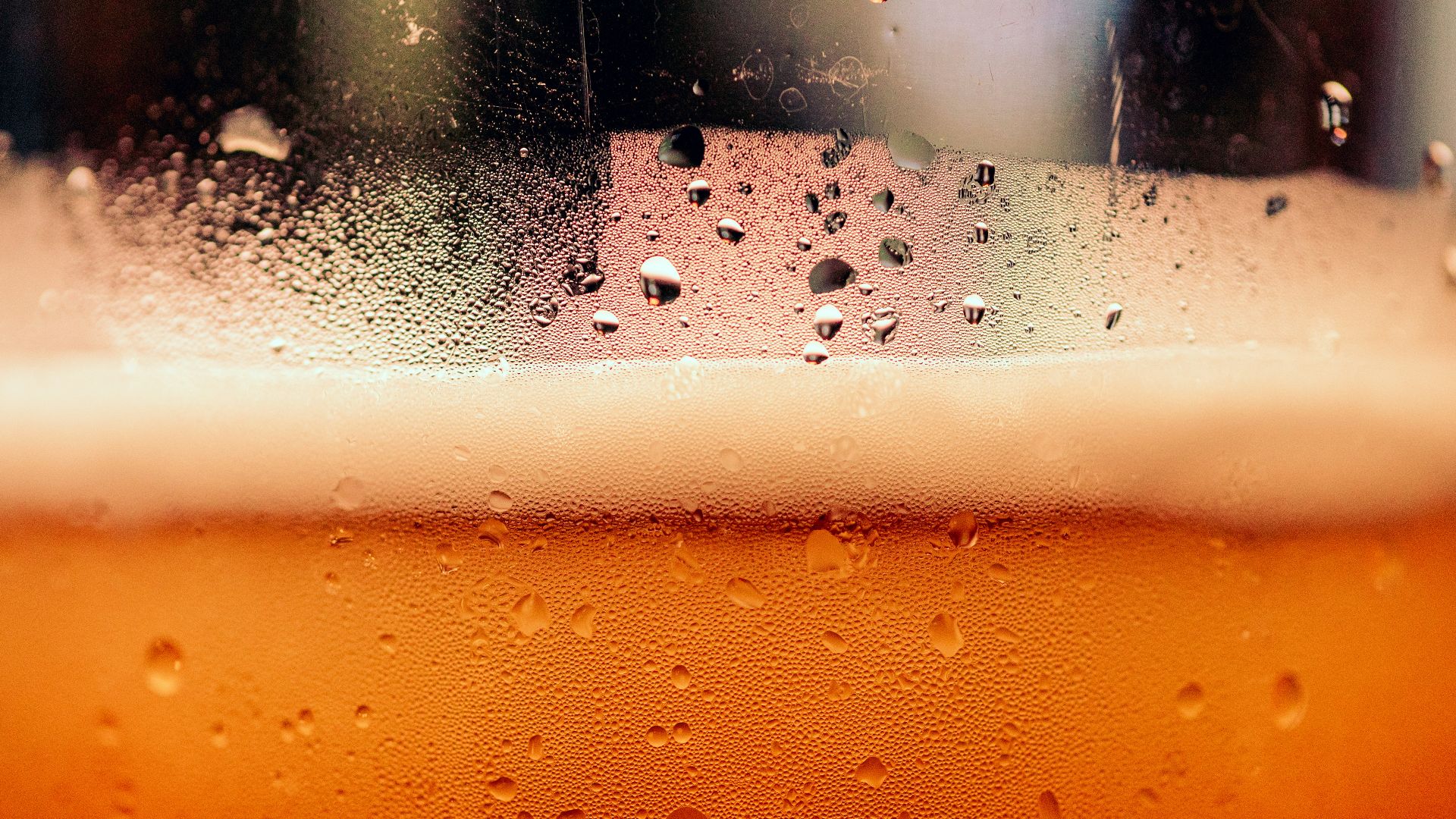 a close up of a glass of beer with drops of water