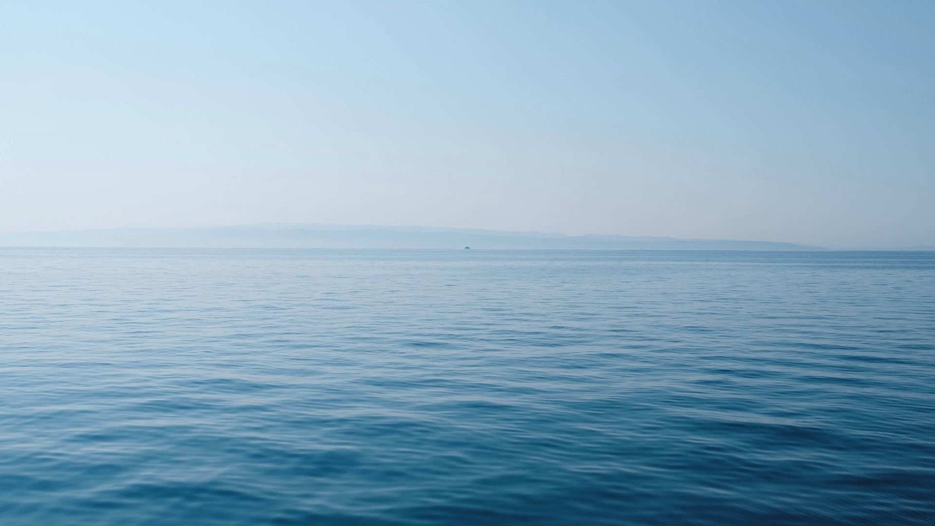 body of water under blue and white sky at daytime