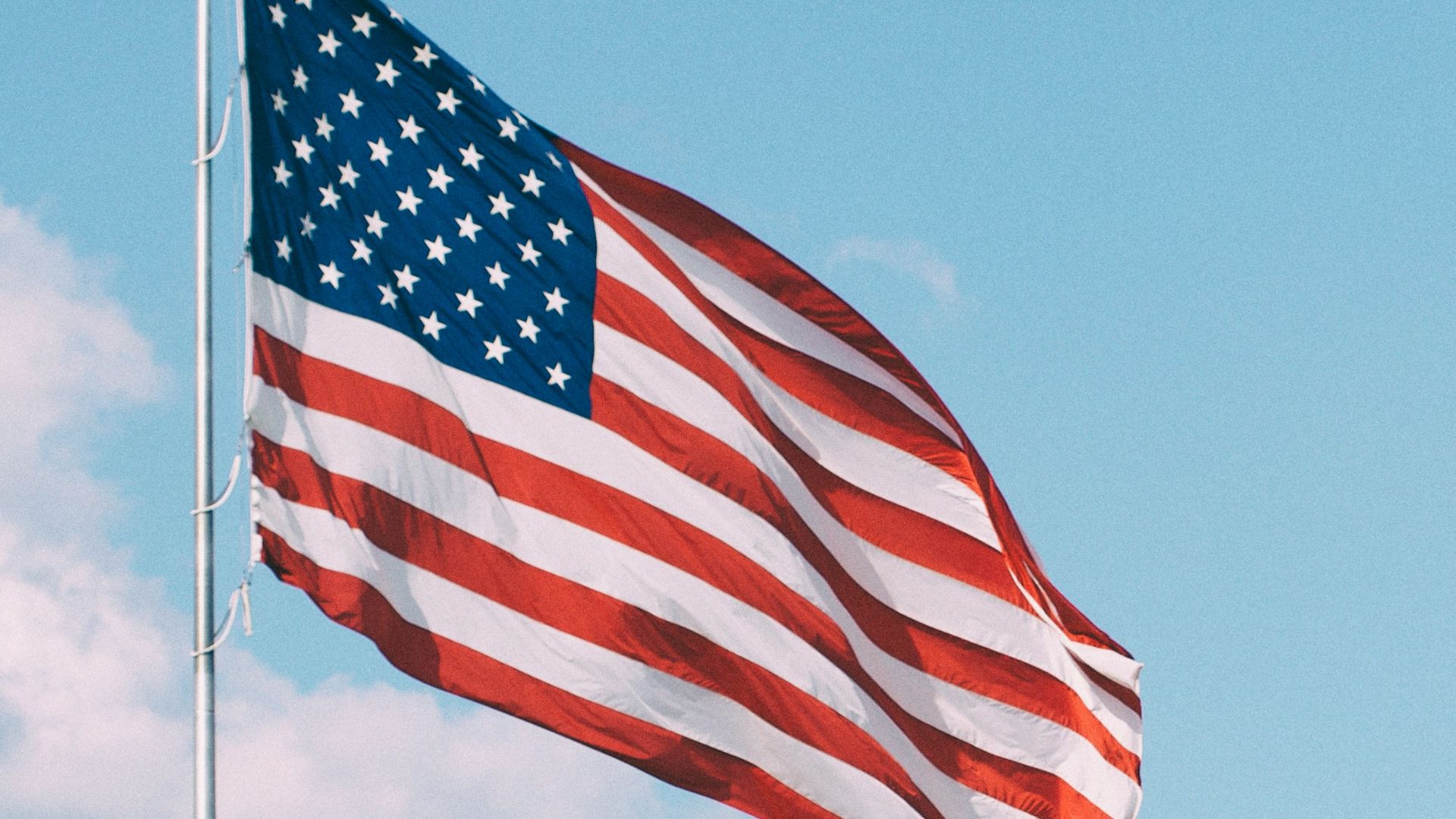 flag of U.S.A. under white clouds during daytime