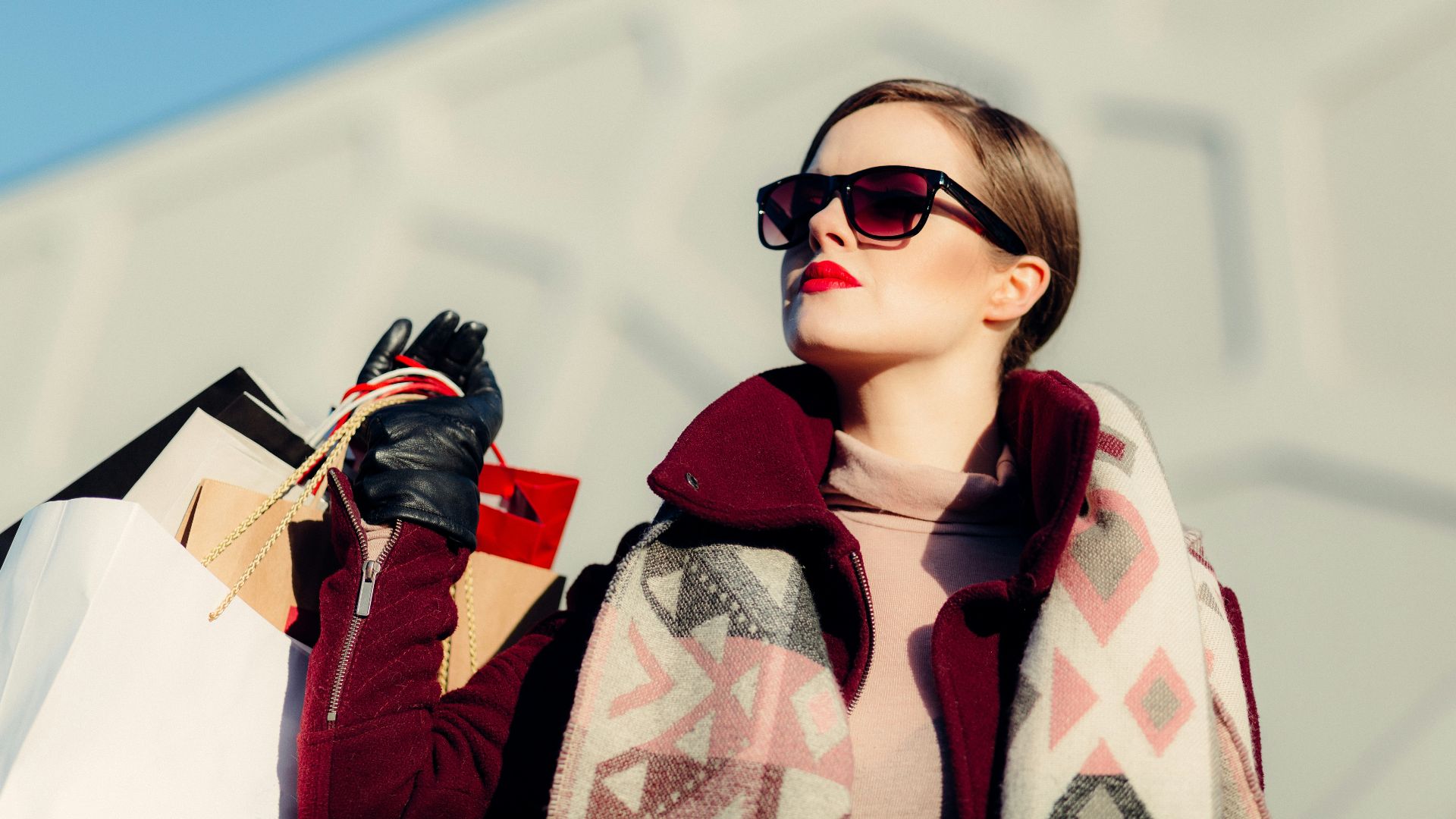 shallow focus photography of woman holding shopping bags during day