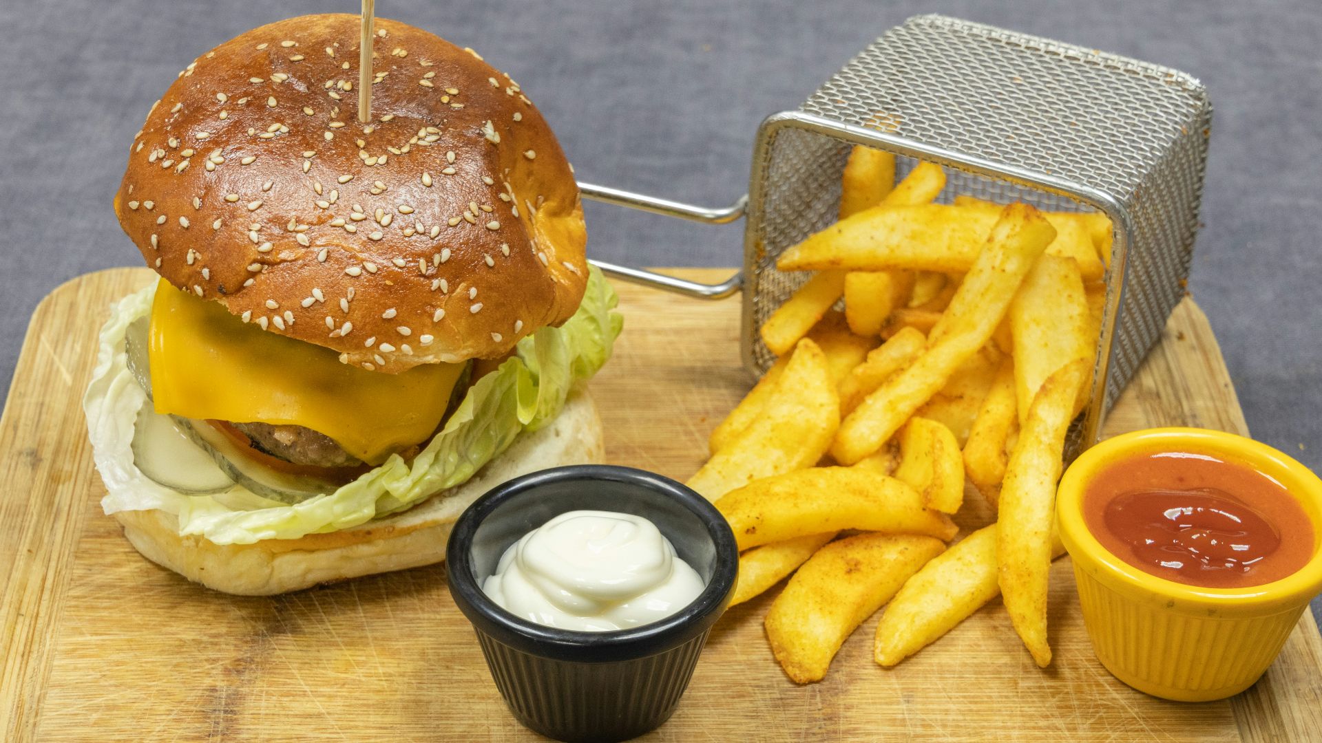 burger and fries on brown wooden chopping board