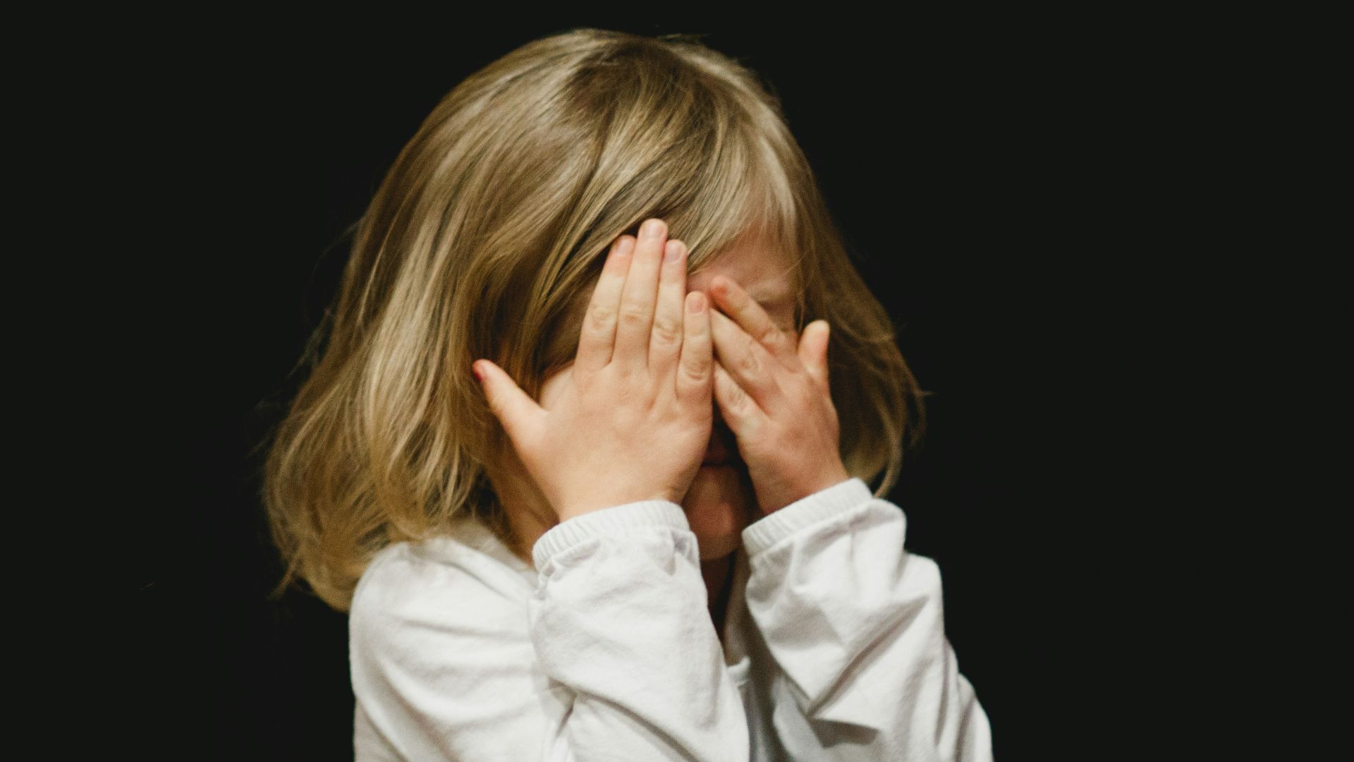 girl covering her face with both hands