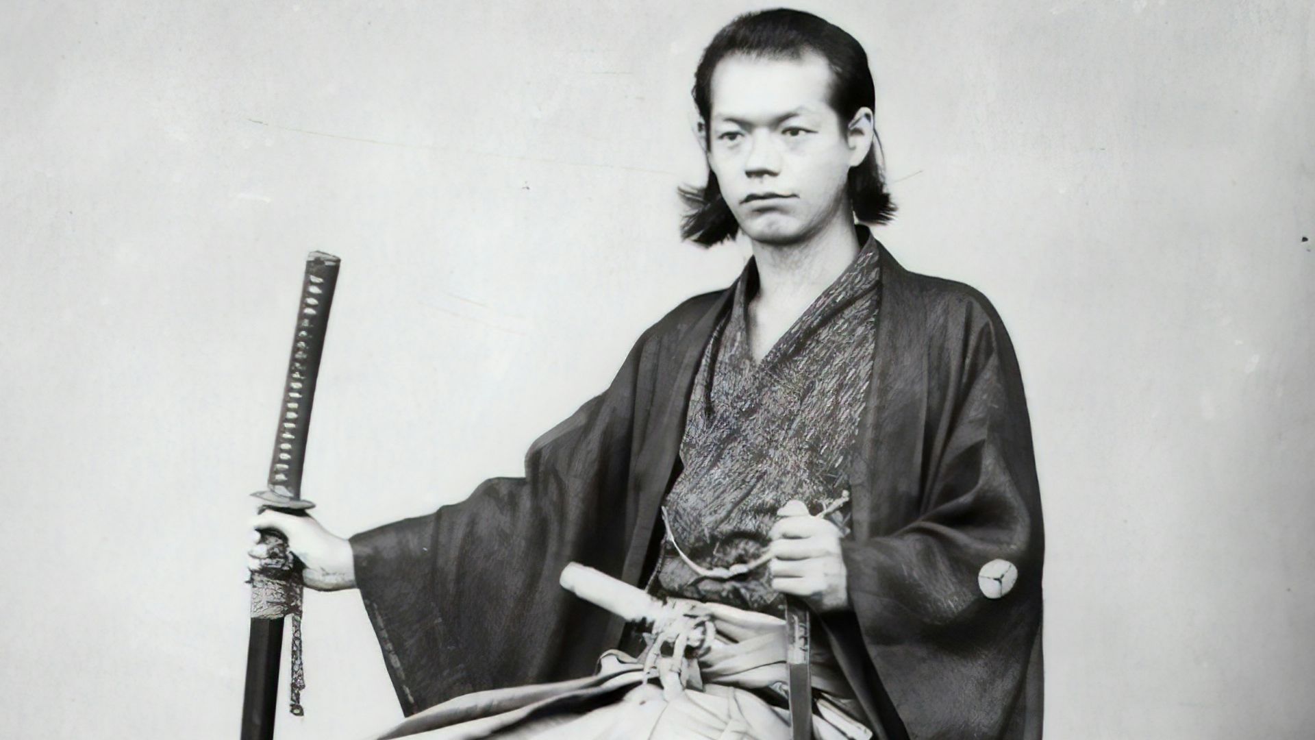 man in black coat and pants sitting on chair