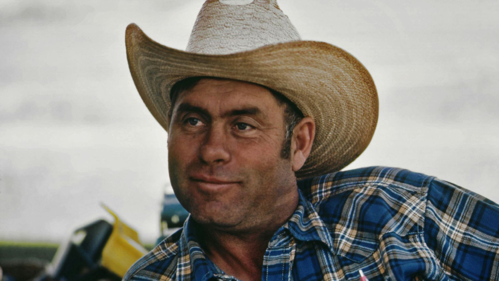 a man wearing a cowboy hat and a plaid shirt