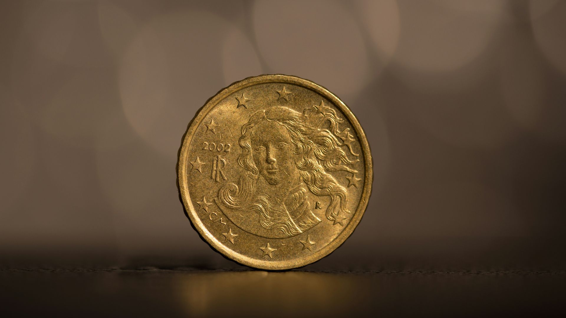 gold round coin on white surface