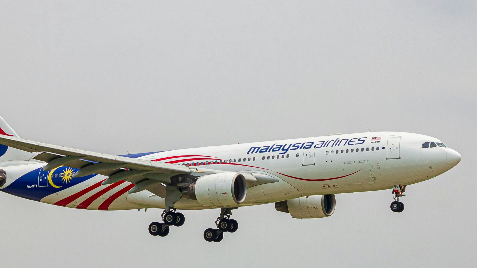 A large jetliner flying through a cloudy sky
