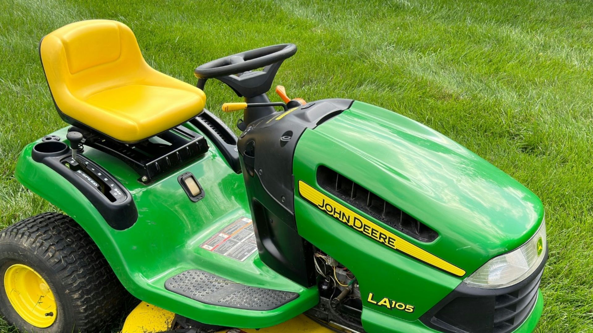 a green lawn mower sitting on top of a lush green field