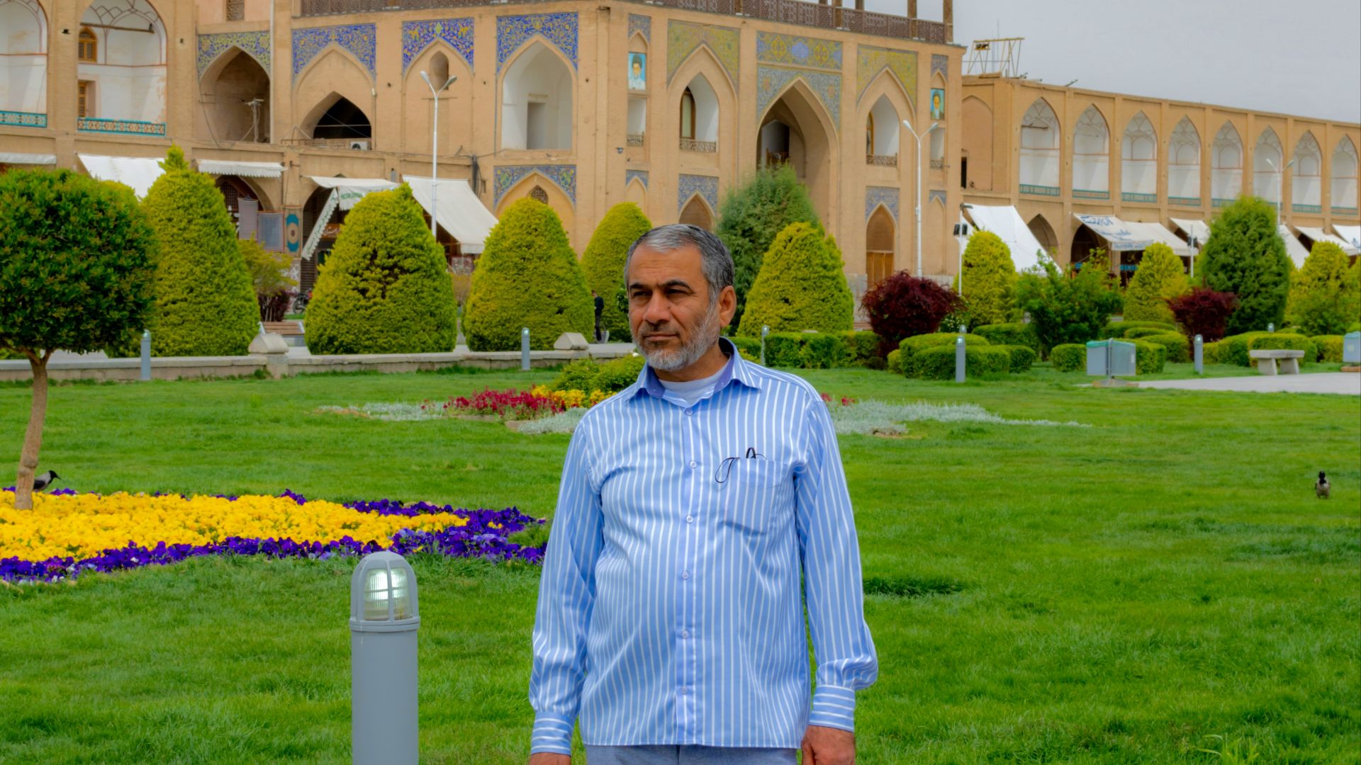 A man standing in front of a large building