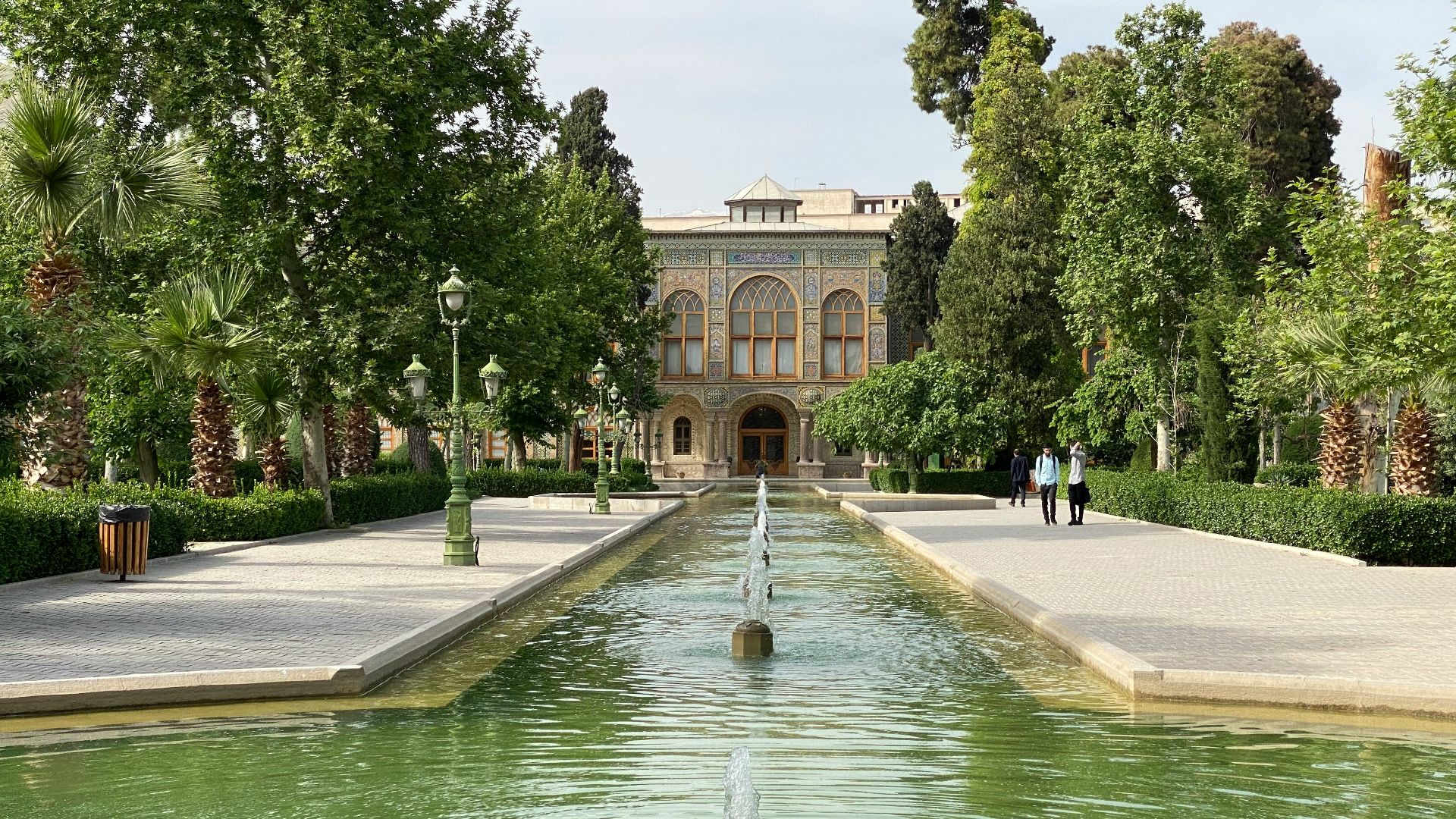 a large building with a fountain in the middle of a pond
