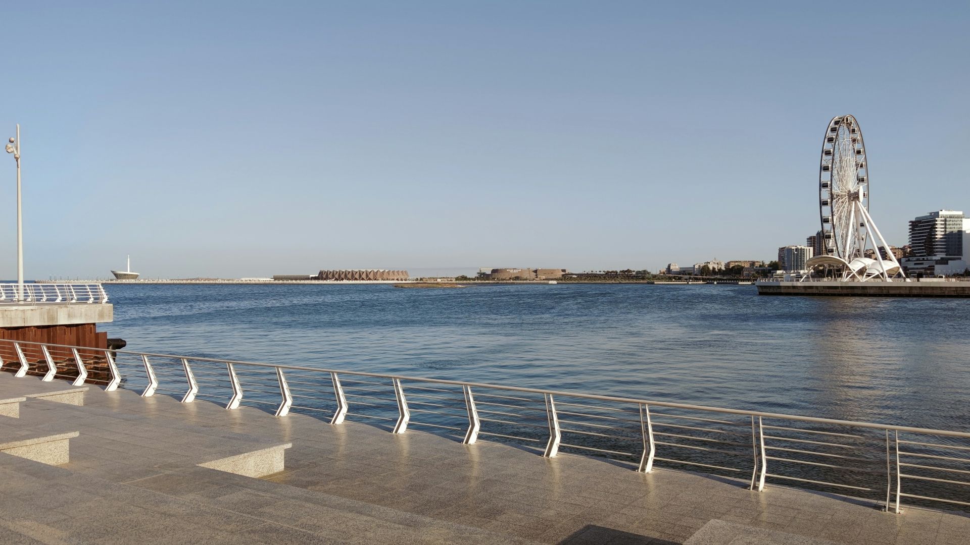 a large body of water with a ferris wheel in the background