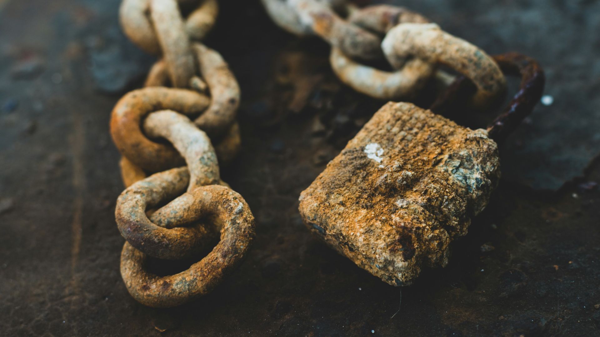 selective focus photography of gray rust-covered chain and padlock