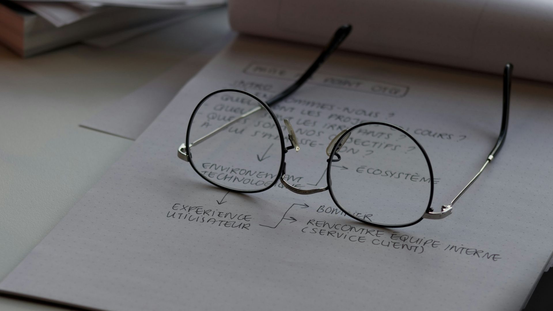 black framed eyeglasses on top of white printing paper