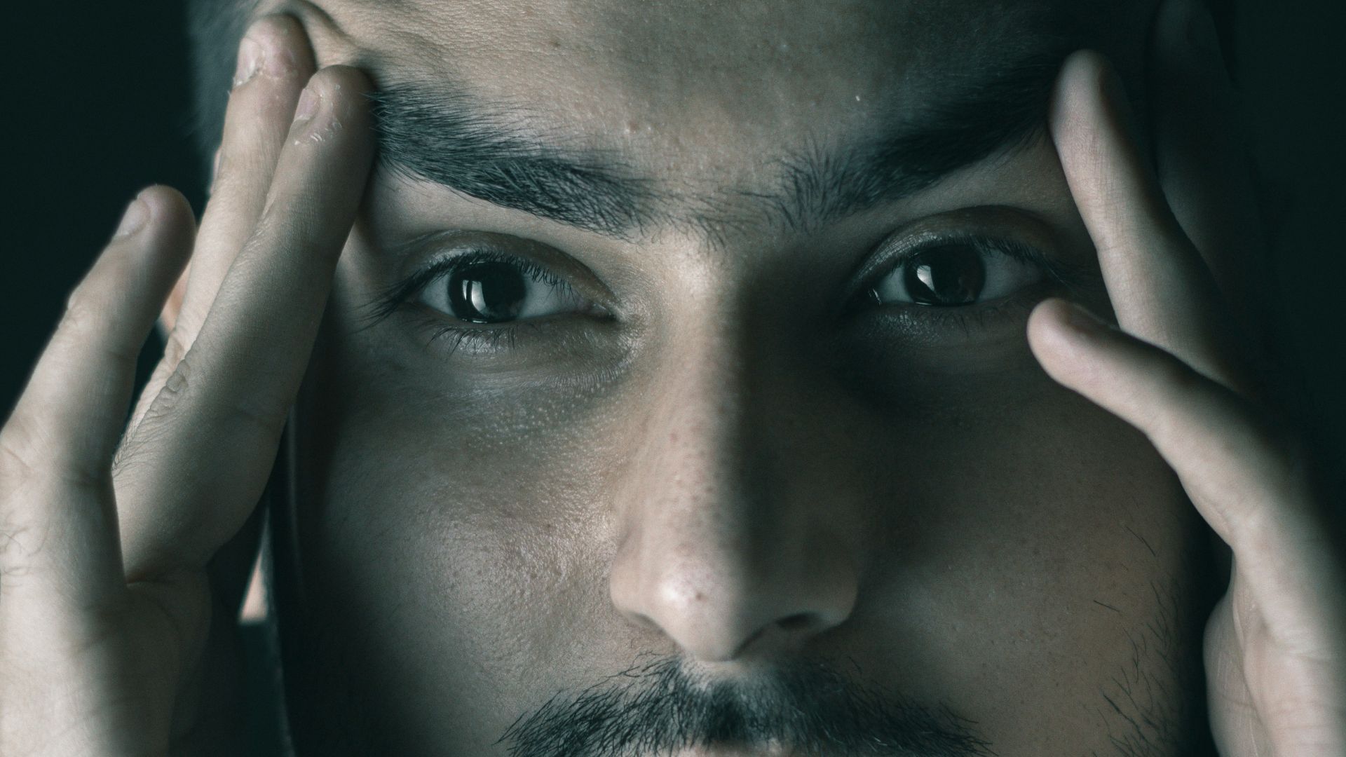 a man with his hands on his face