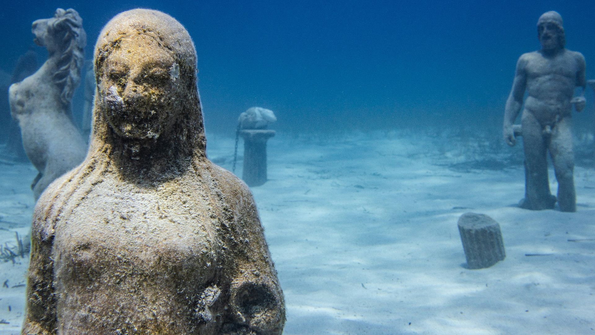 a statue of a man and a woman in the water