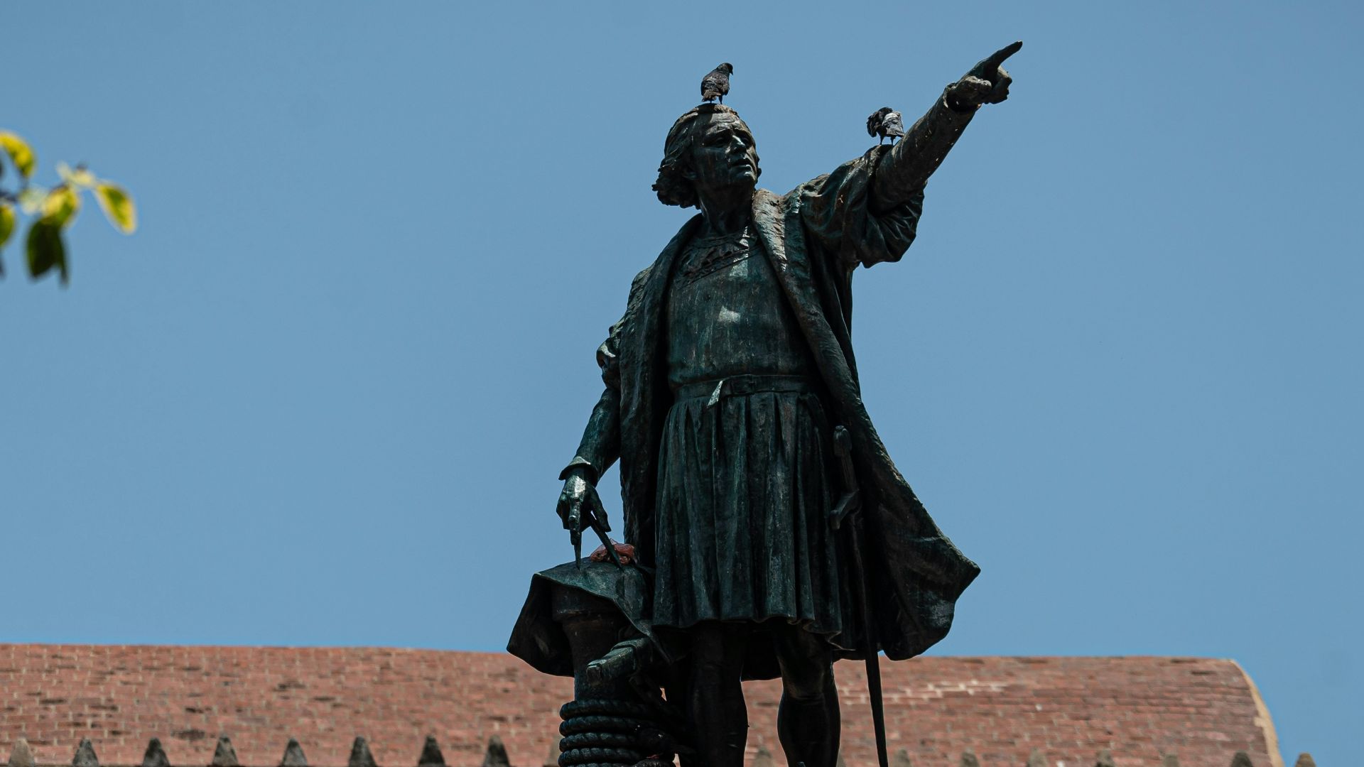 black statue of man holding yellow umbrella