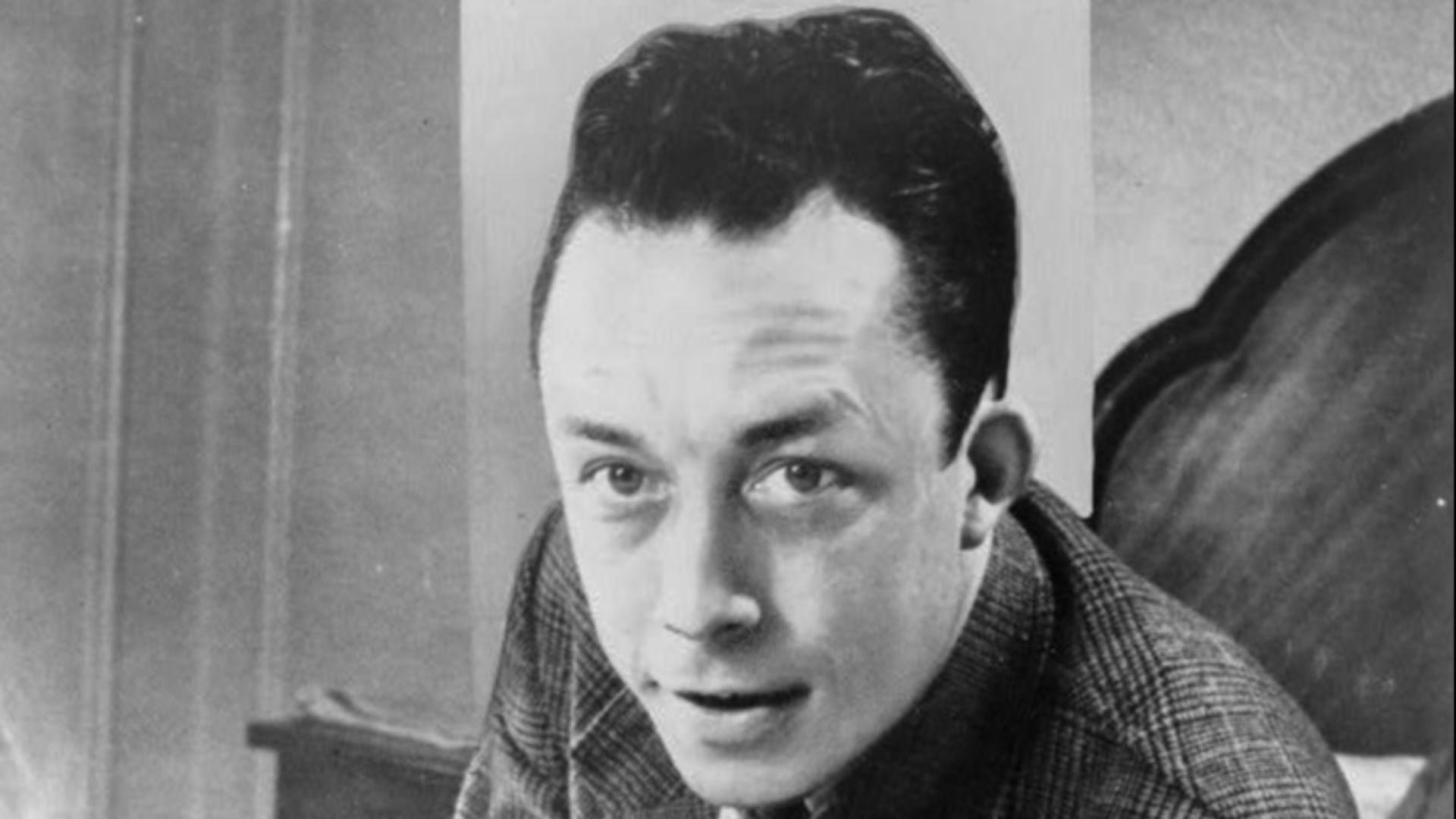 File:Albert Camus, gagnant de prix Nobel, portrait en buste, posé au bureau, faisant face à gauche, cigarette de tabagisme.jpg