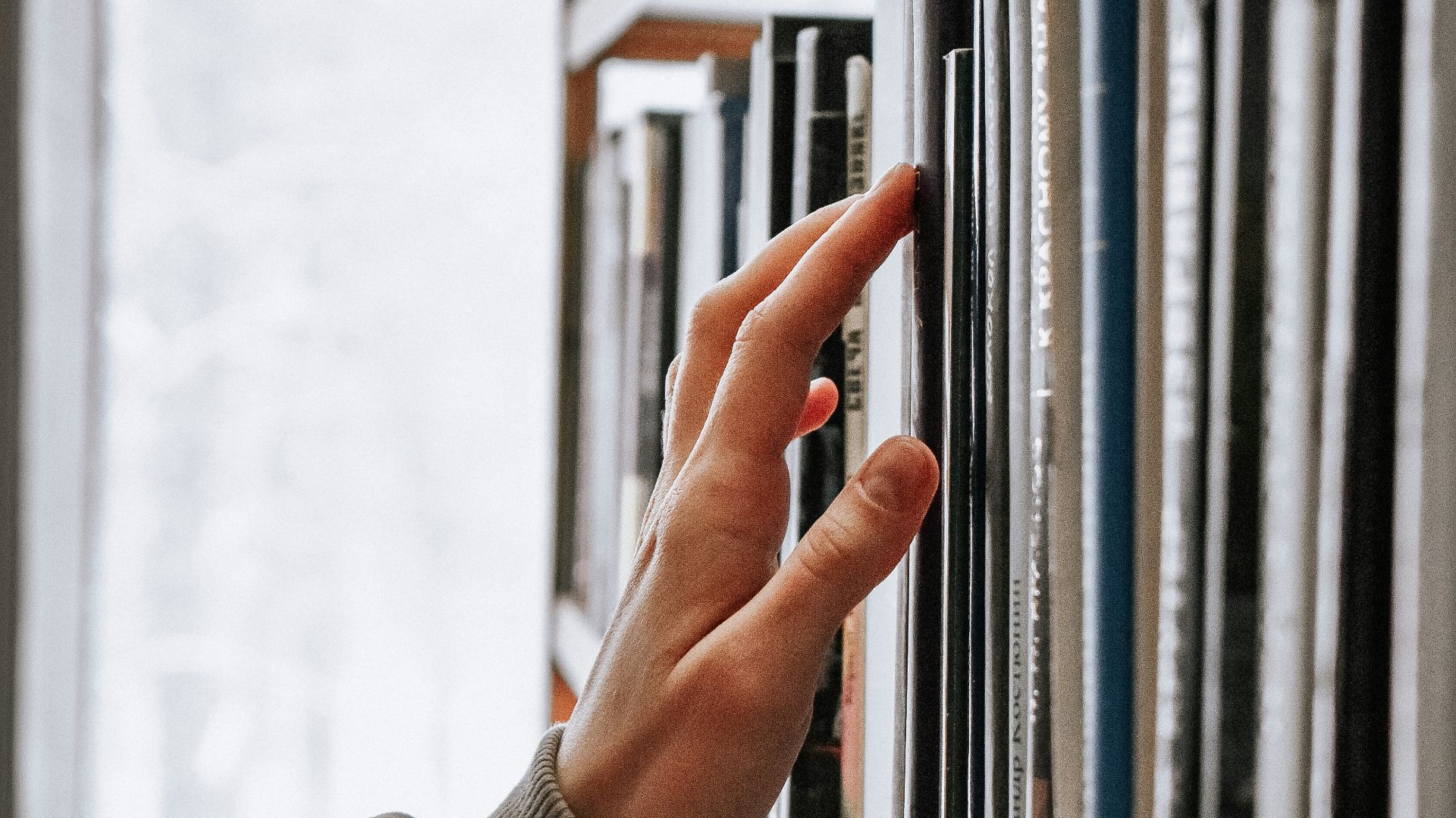 person in white long sleeve shirt holding white book