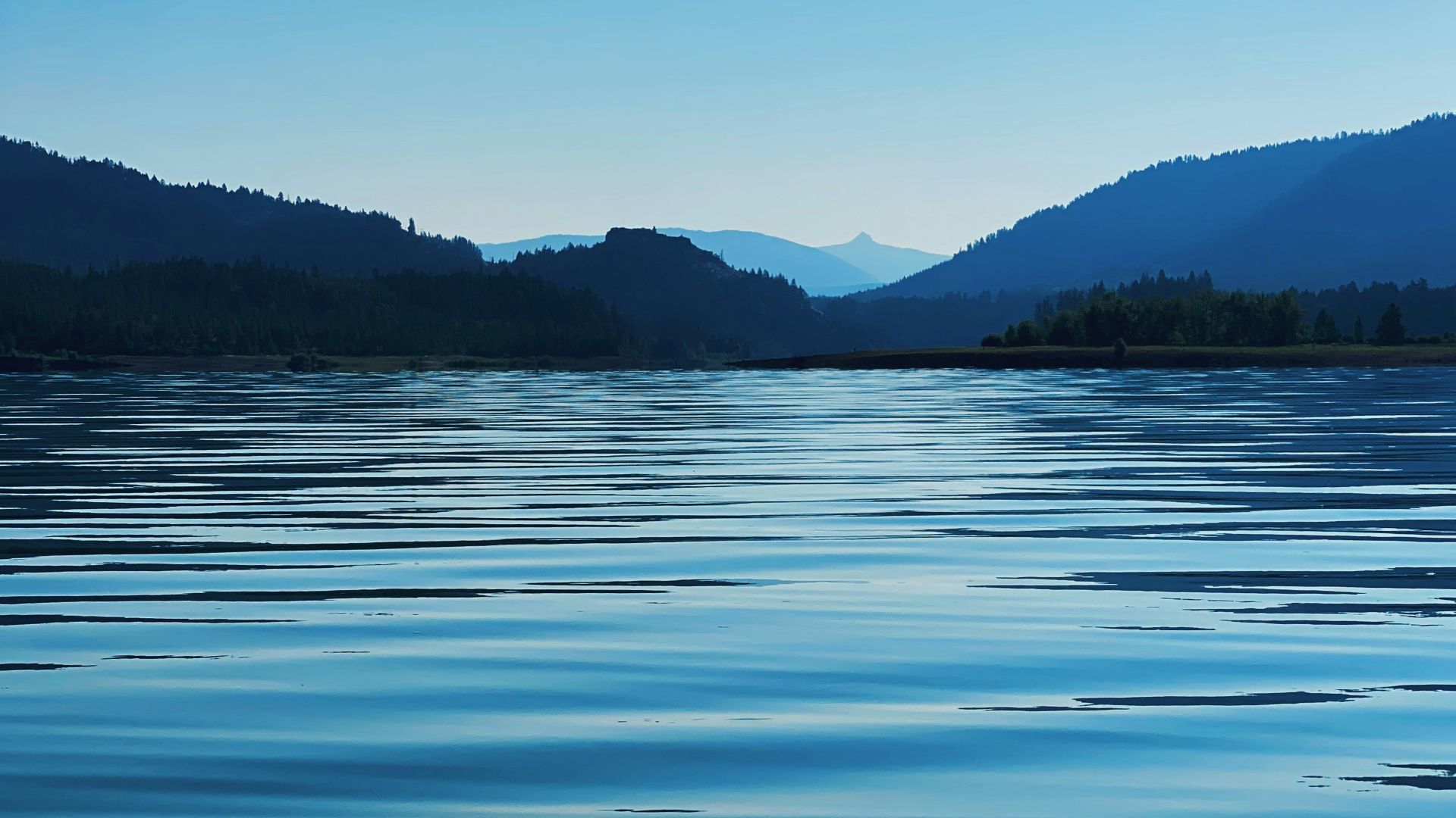 body of water near mountain during daytime