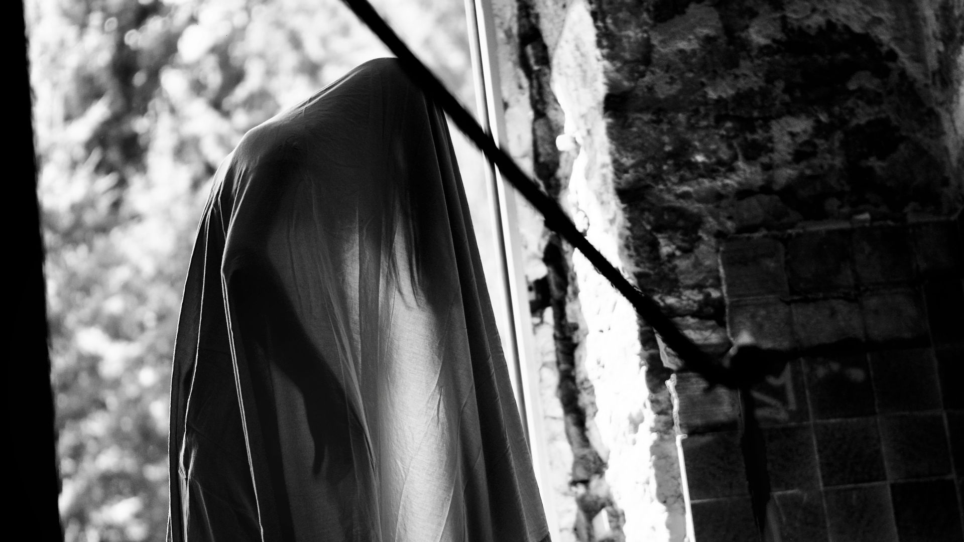 a black and white photo of a robe hanging on a clothes line