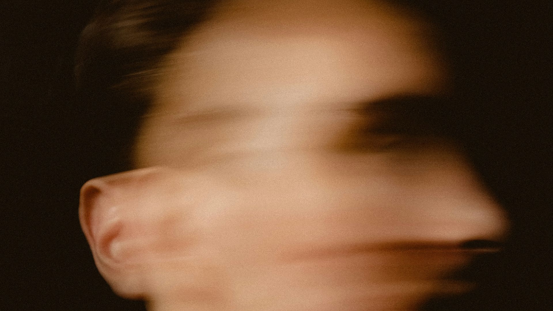 A blurry photo of a man in a white shirt