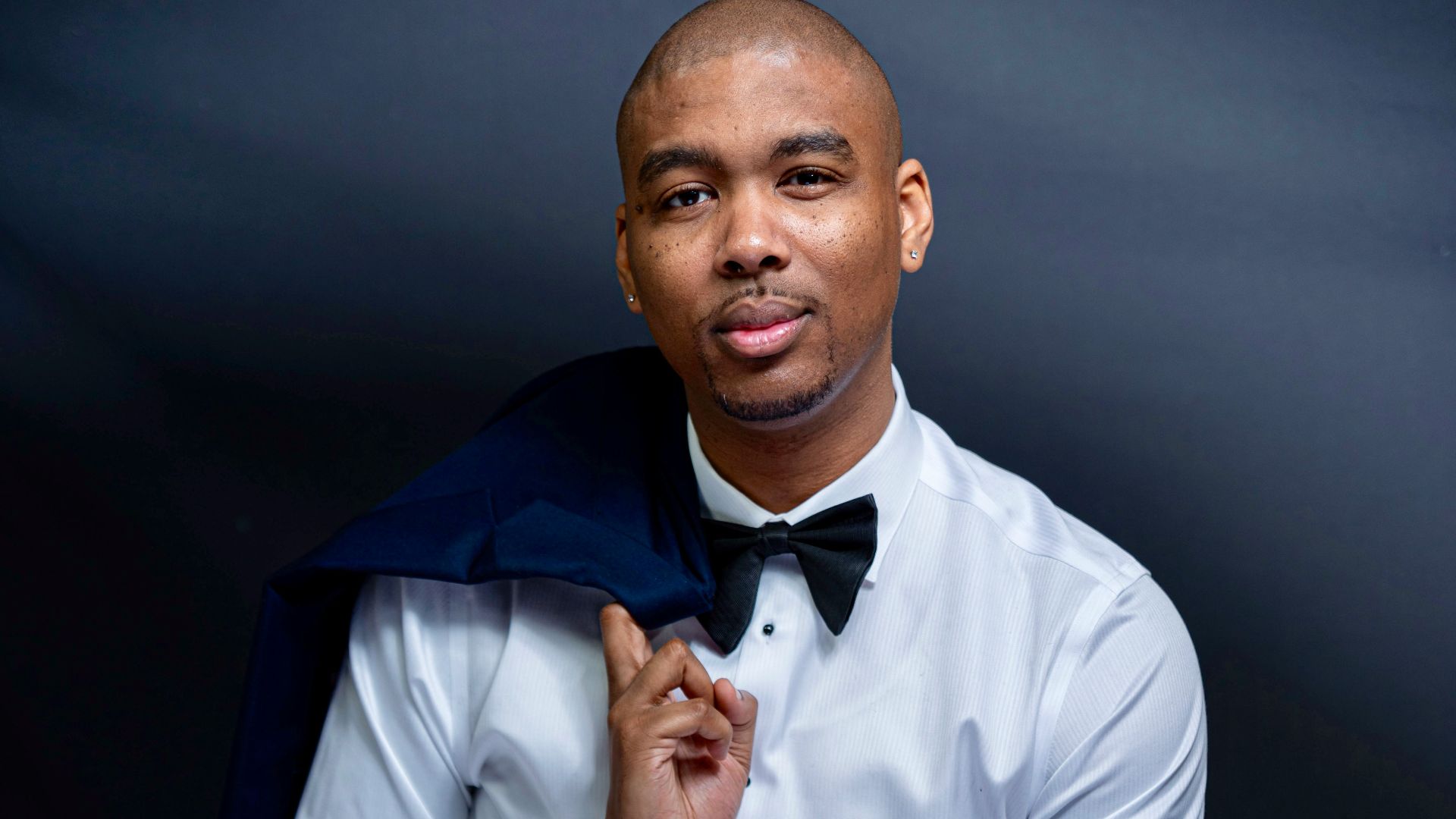 man in white dress shirt and blue pants sitting on black chair