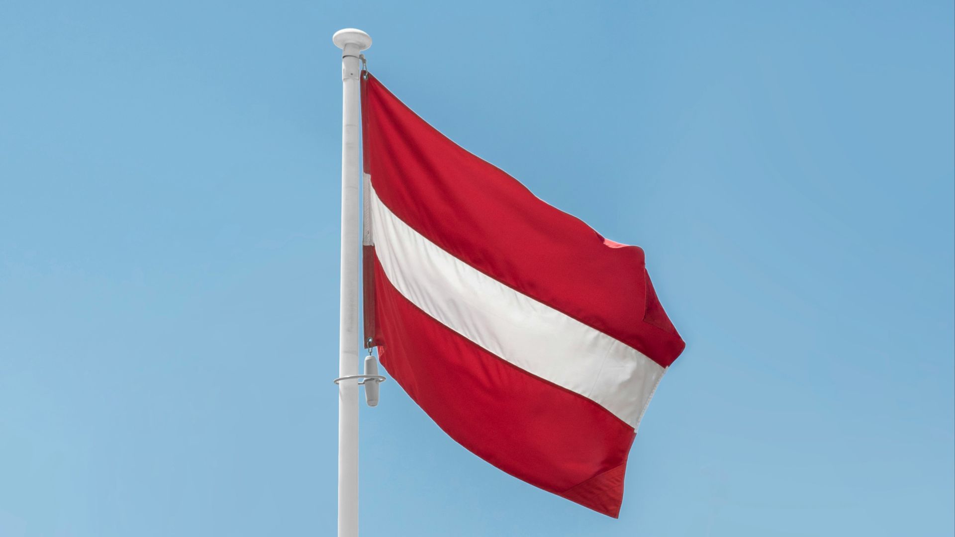a red and white flag on a flagpole