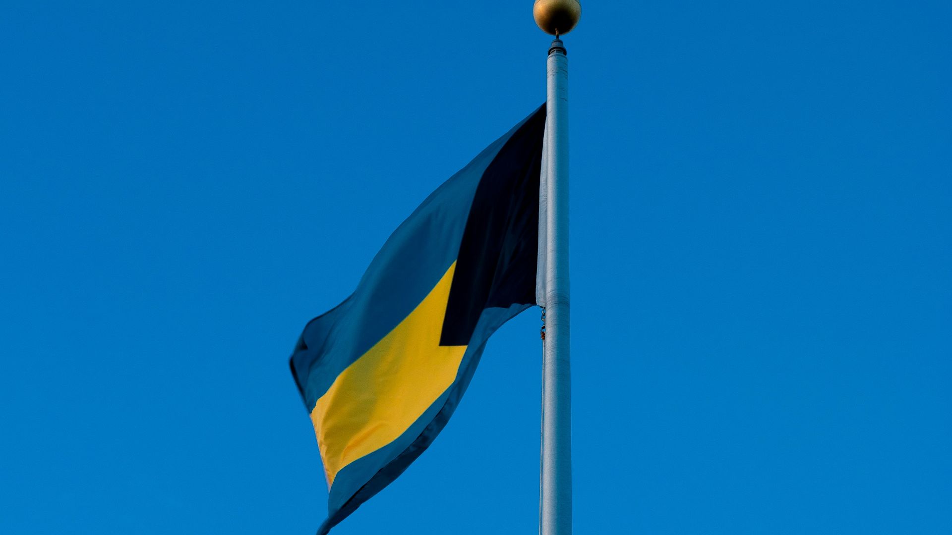 yellow and black flag under blue sky during daytime