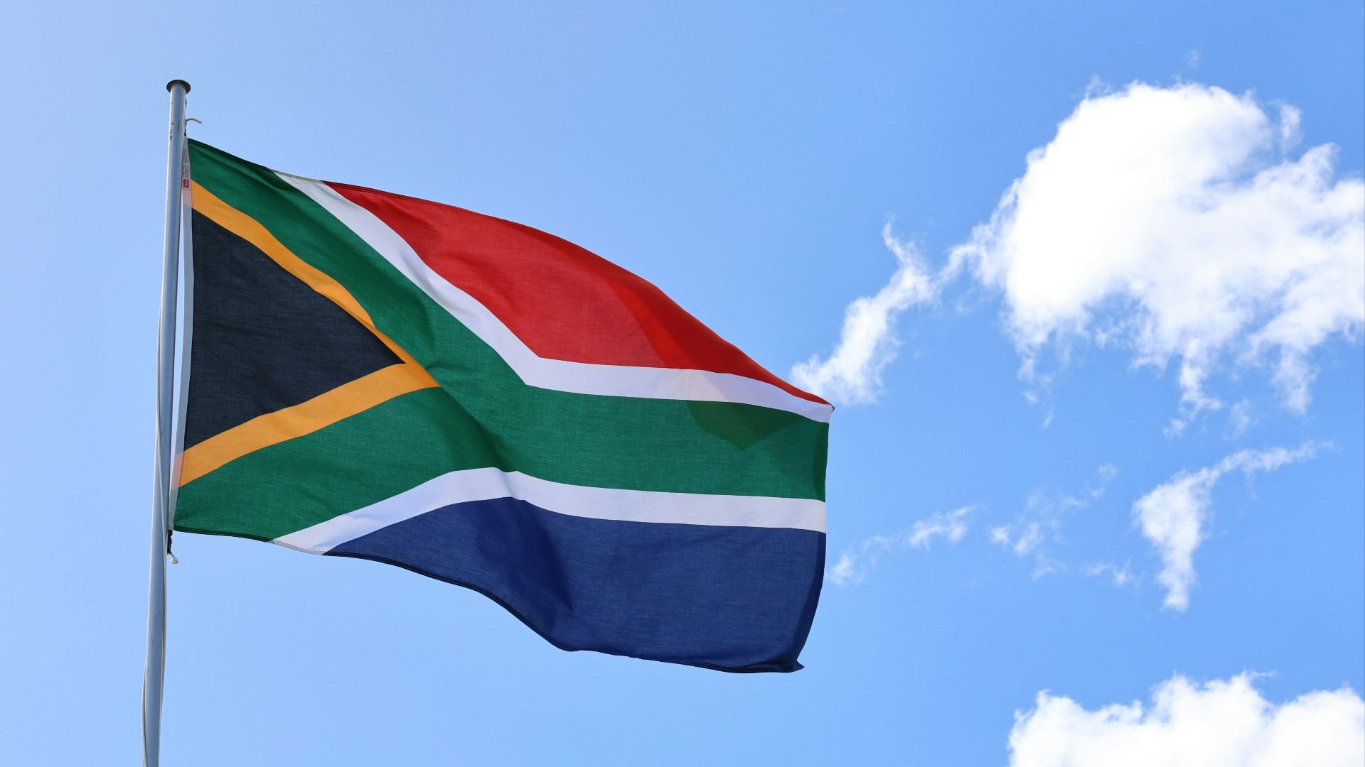 a flag flying in the wind on a sunny day