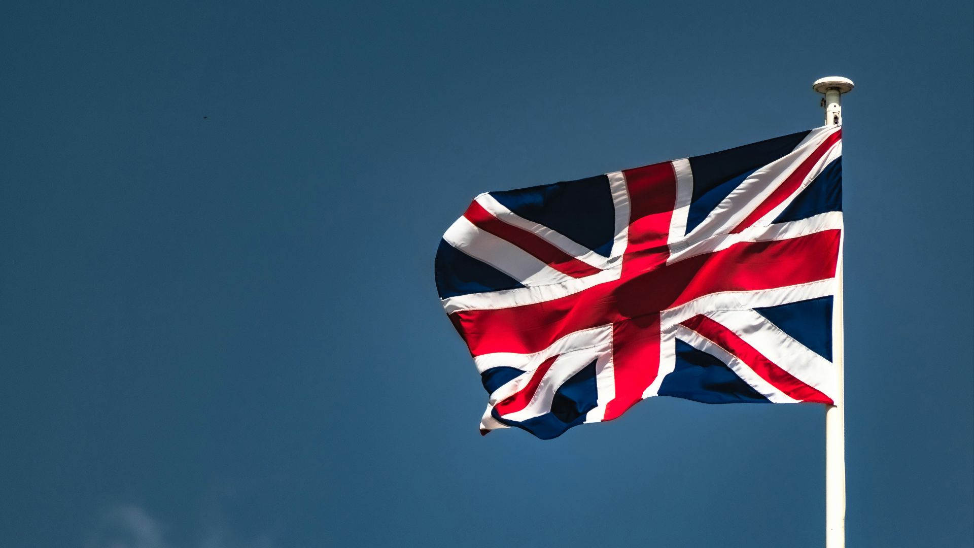 a flag flying in the wind on a clear day